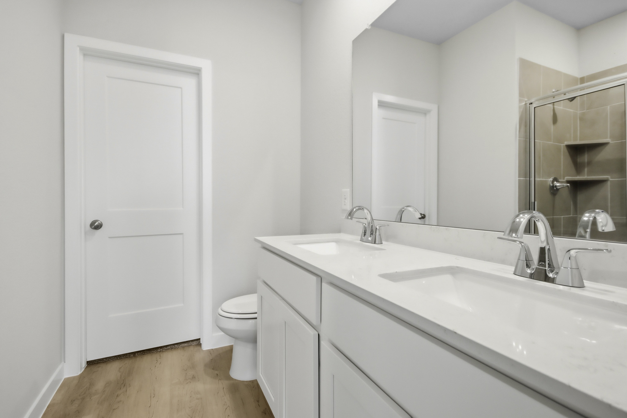 A bathroom with a sink toilet and mirror.