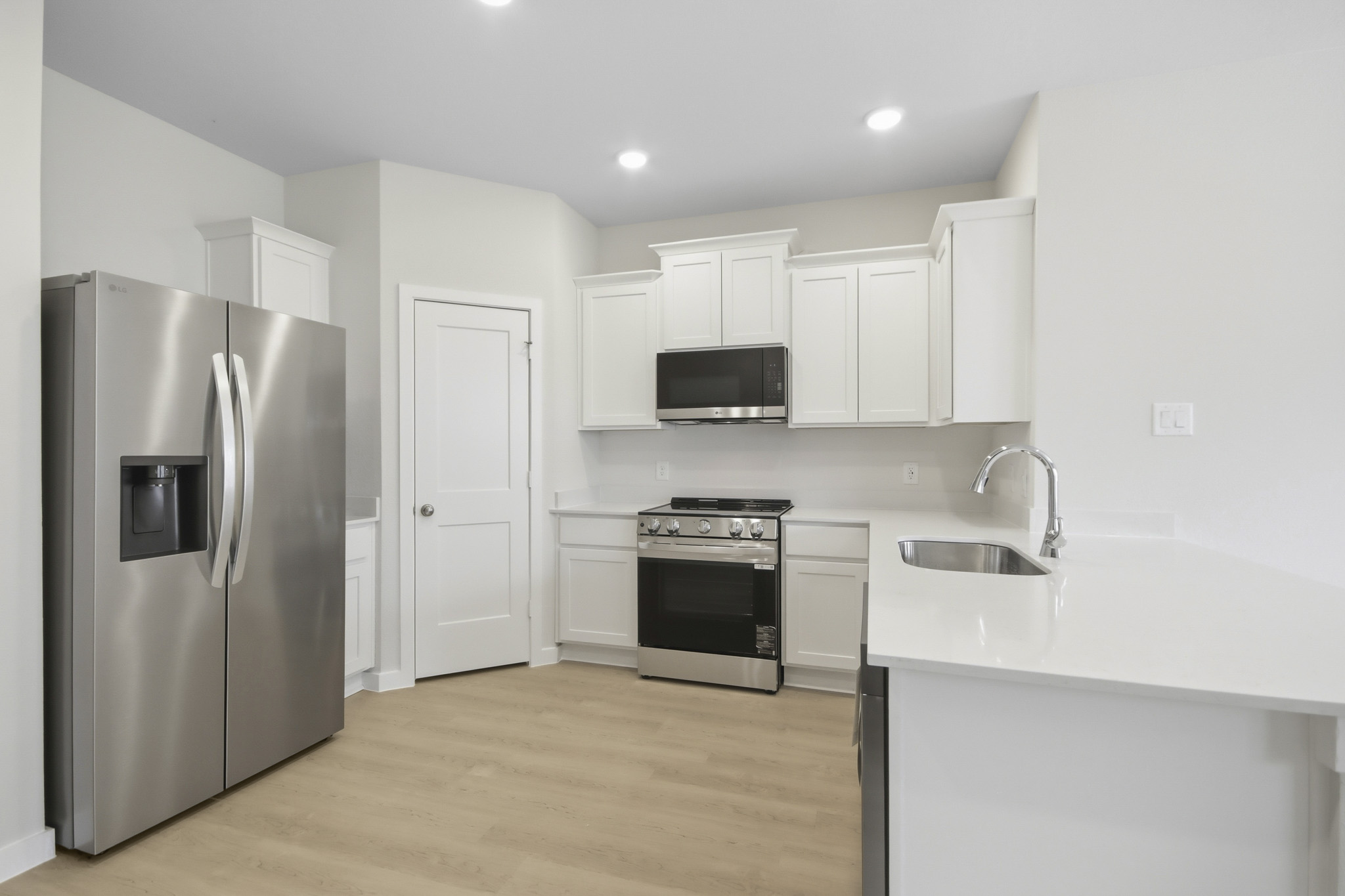 A kitchen with white cabinets.
