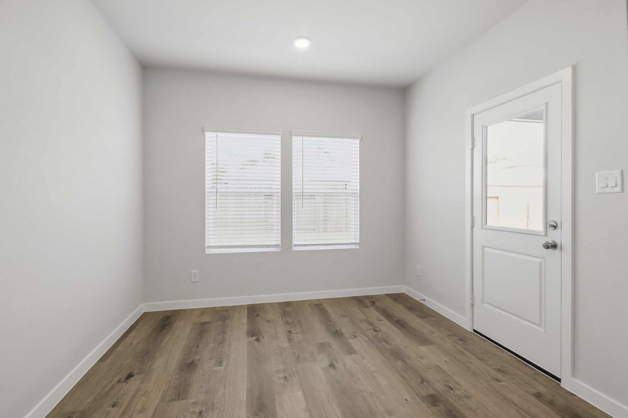 A room with white doors and a wood floor.