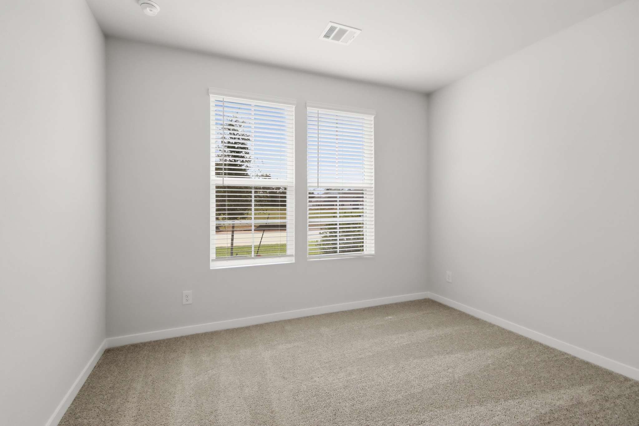 A room with a window and a carpet.