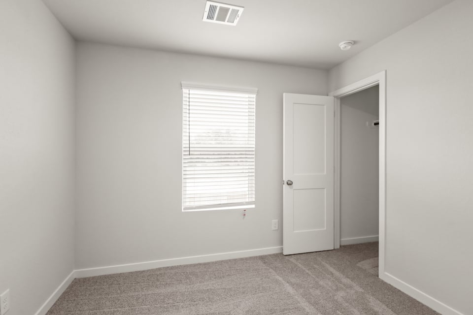 A room with white walls and a door with a window.