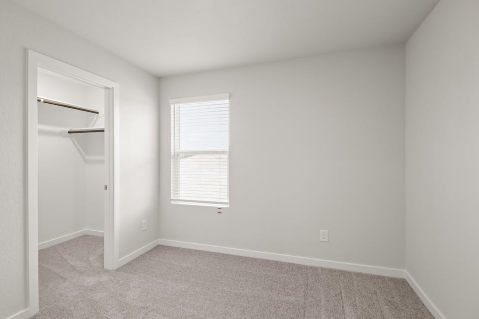 A room with a window and a shelf.