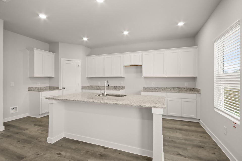 A kitchen with white cabinets.