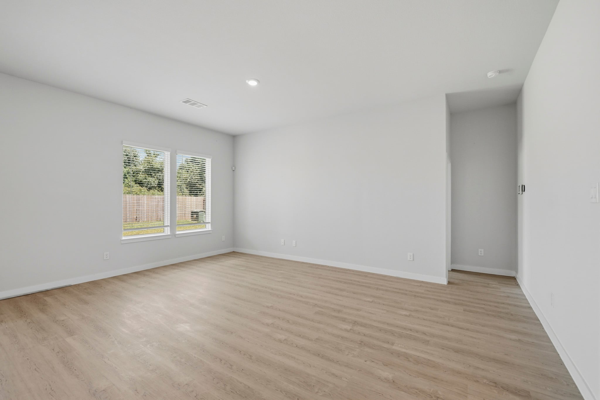 A room with a wood floor and a window.