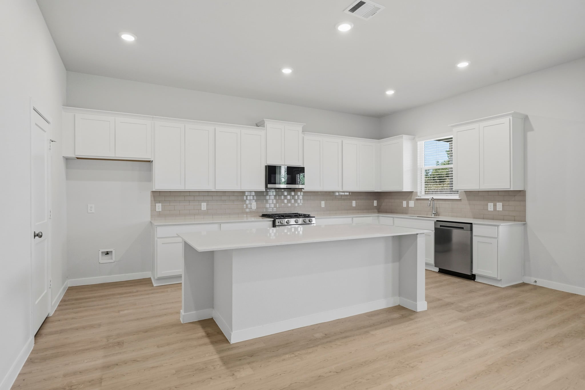 A kitchen with white cabinets.