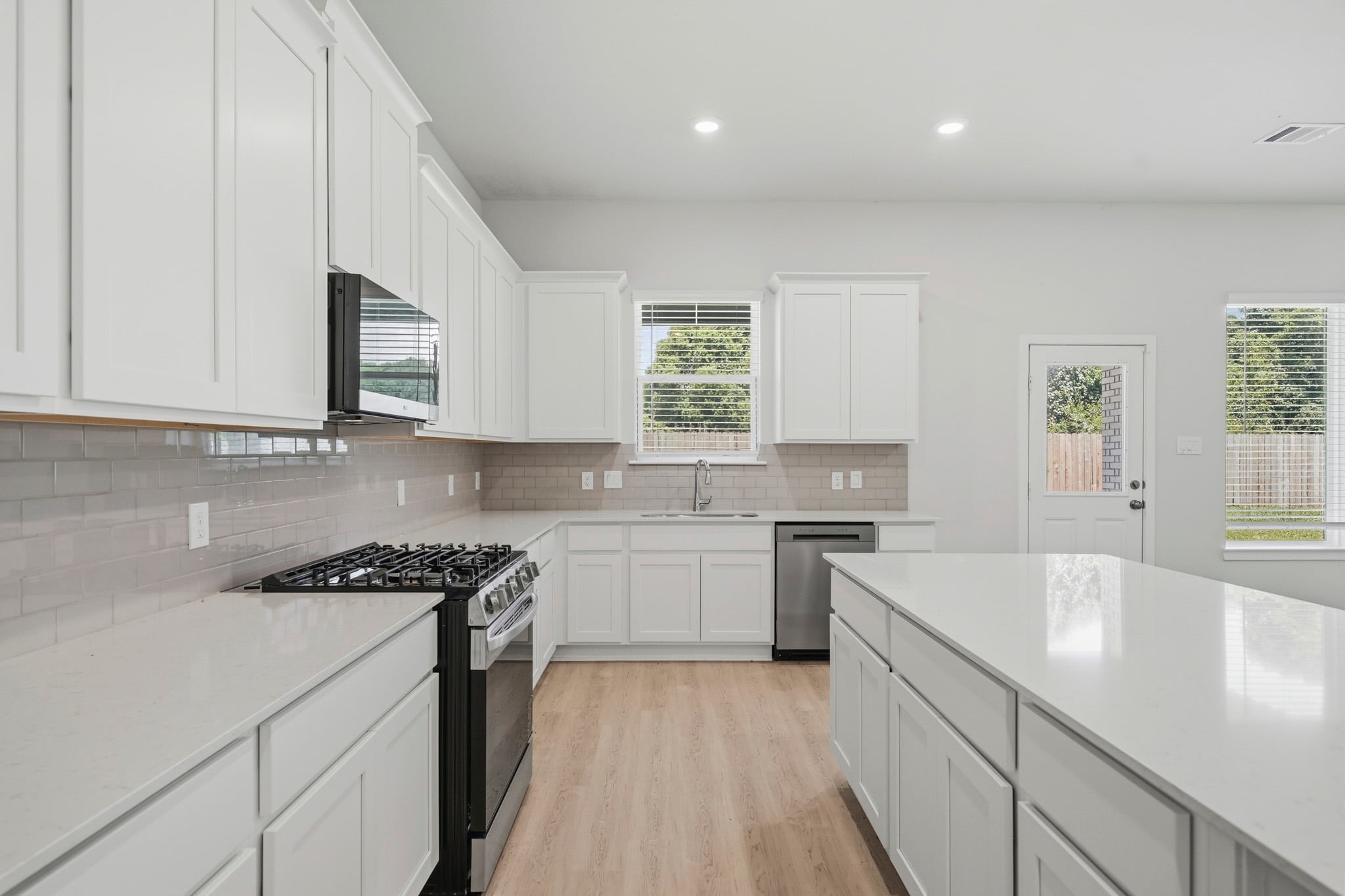 A kitchen with white cabinets.