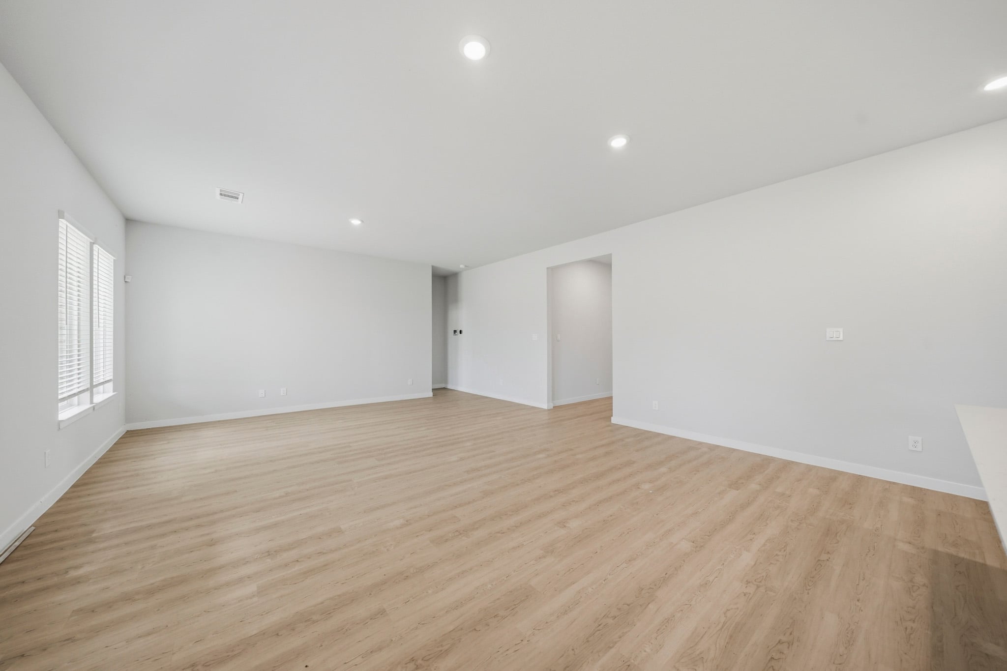 A room with a wood floor and white walls.