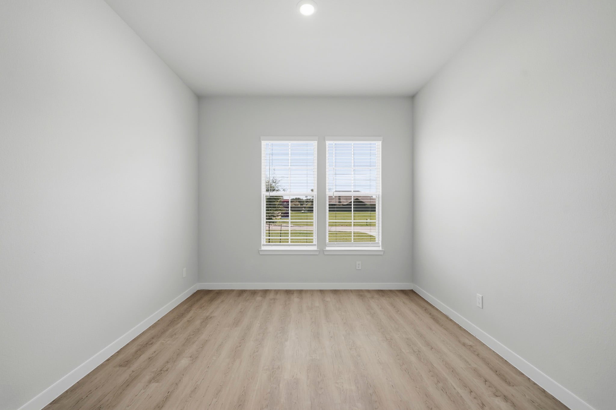 A room with a wood floor and a window.