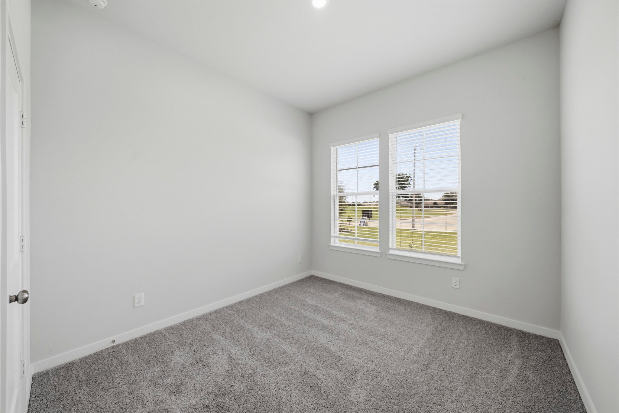 A room with a carpet and windows.