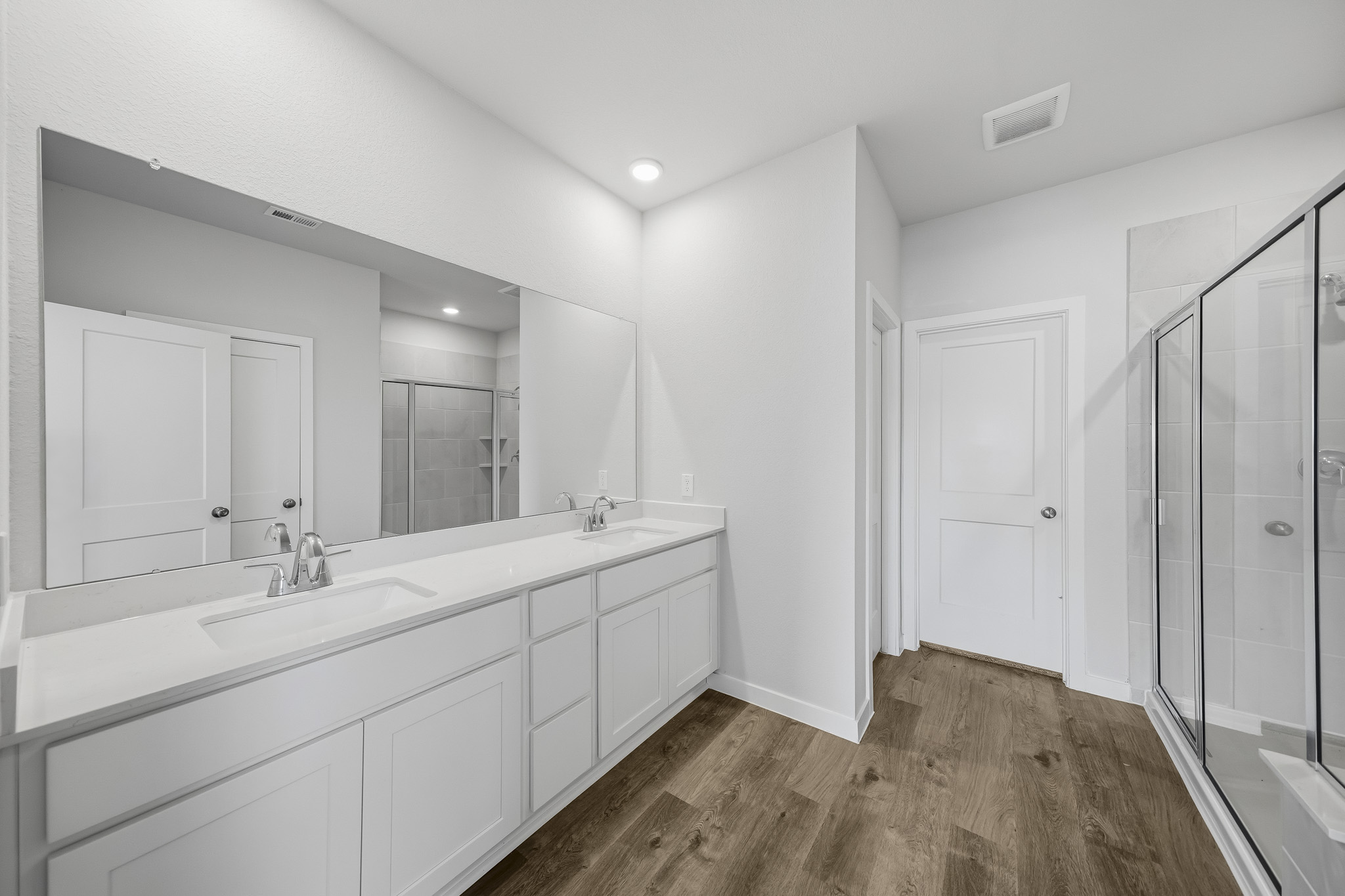 A bathroom with white cabinets.