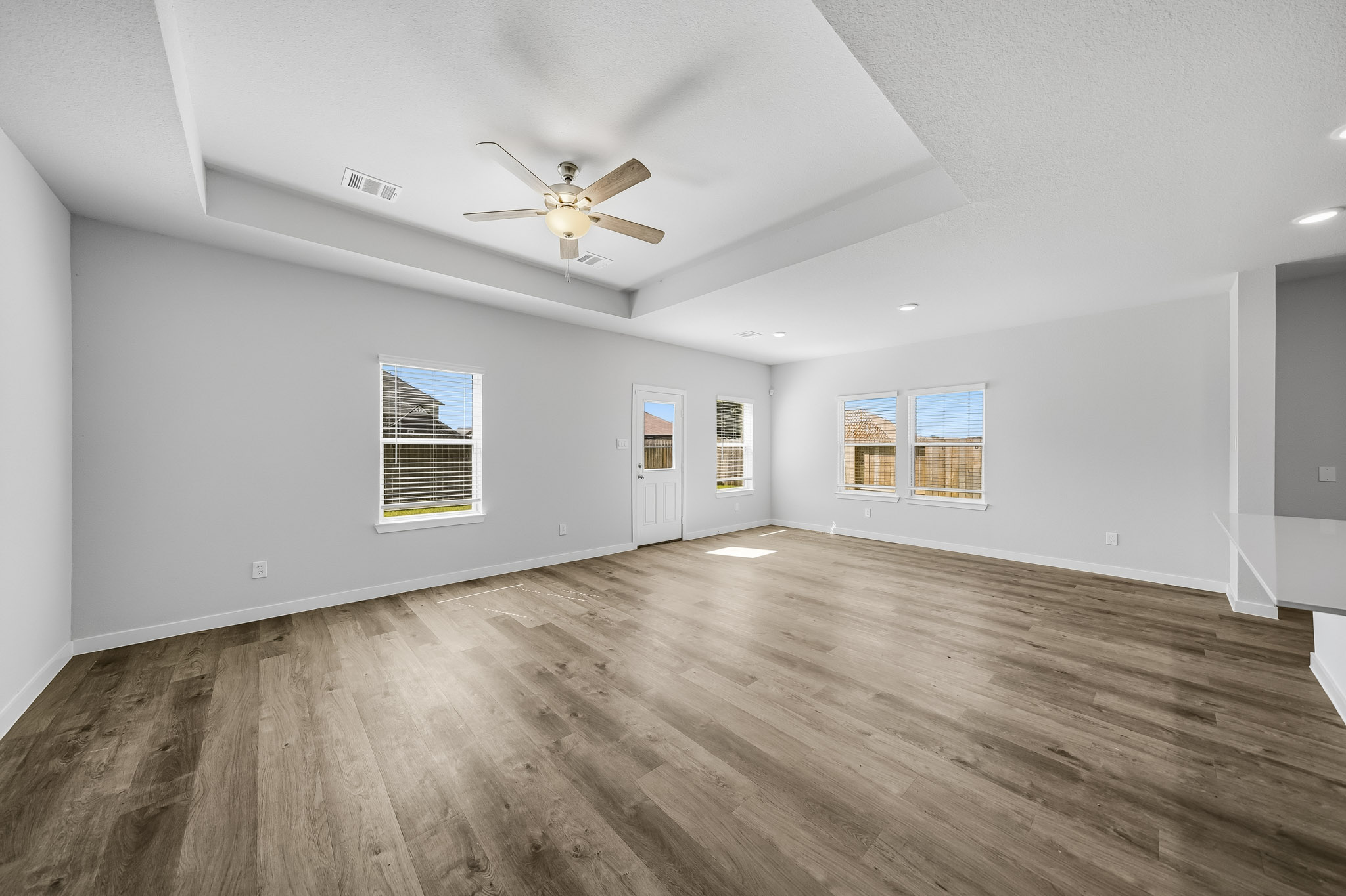 A room with a wood floor and a ceiling fan.