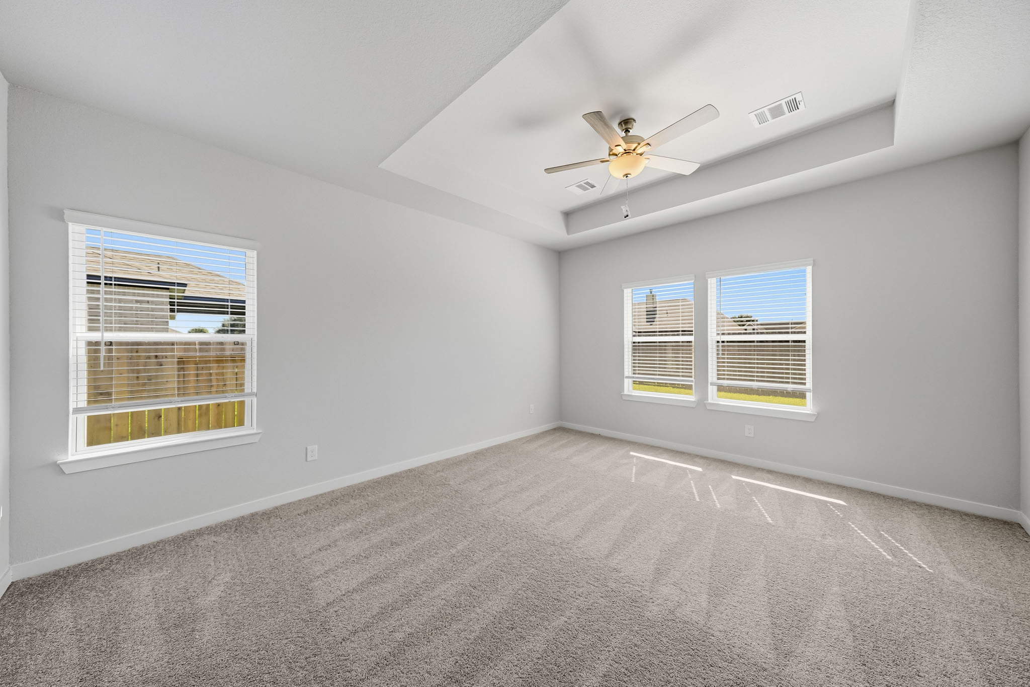 A room with a ceiling fan and a window.