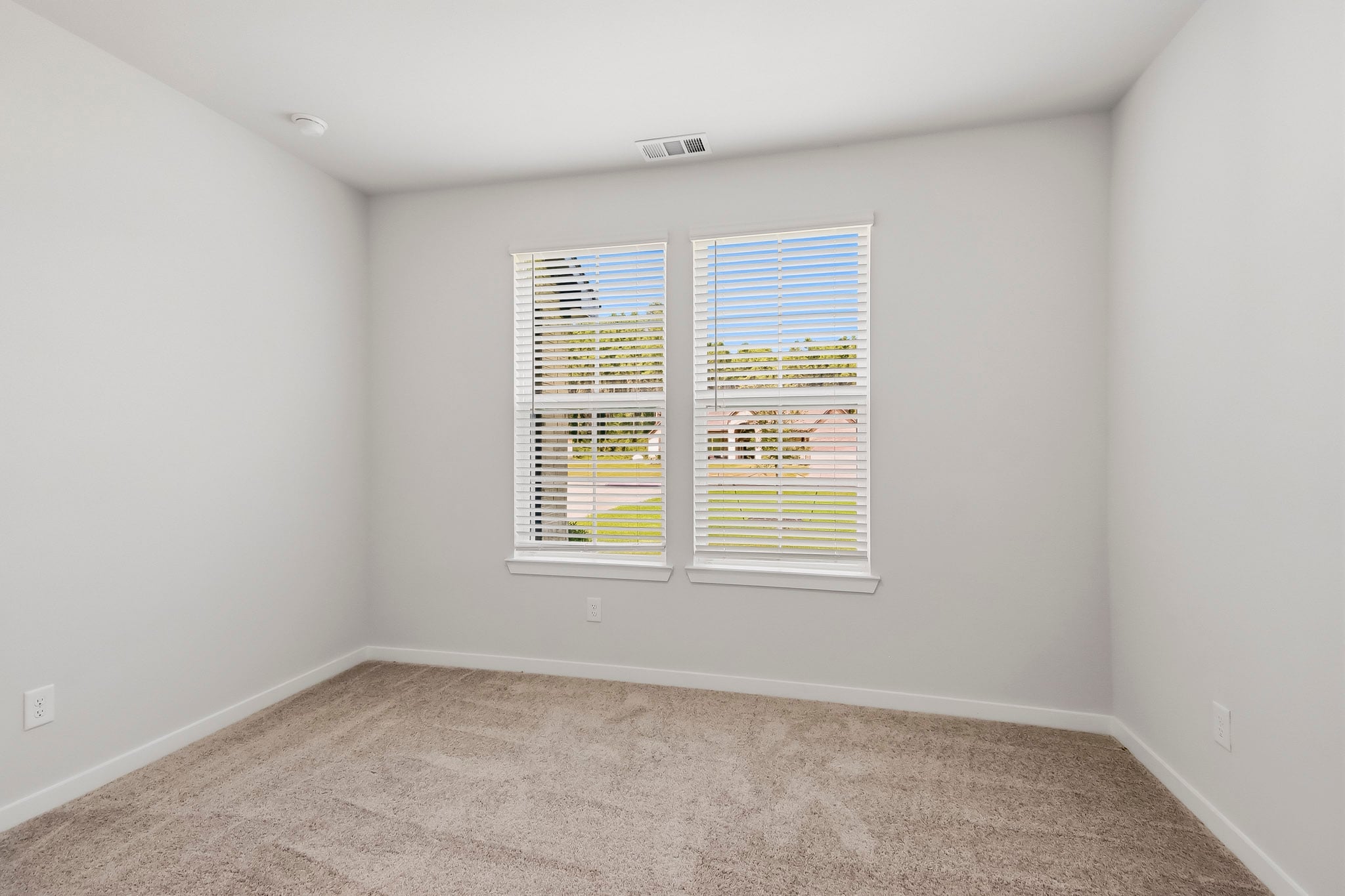 A room with a window and carpet.