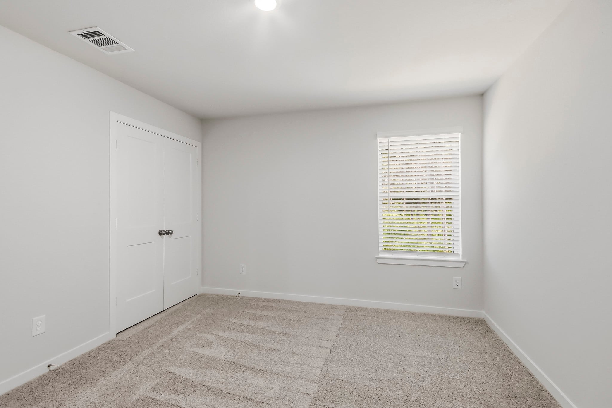 A room with white walls and a window.