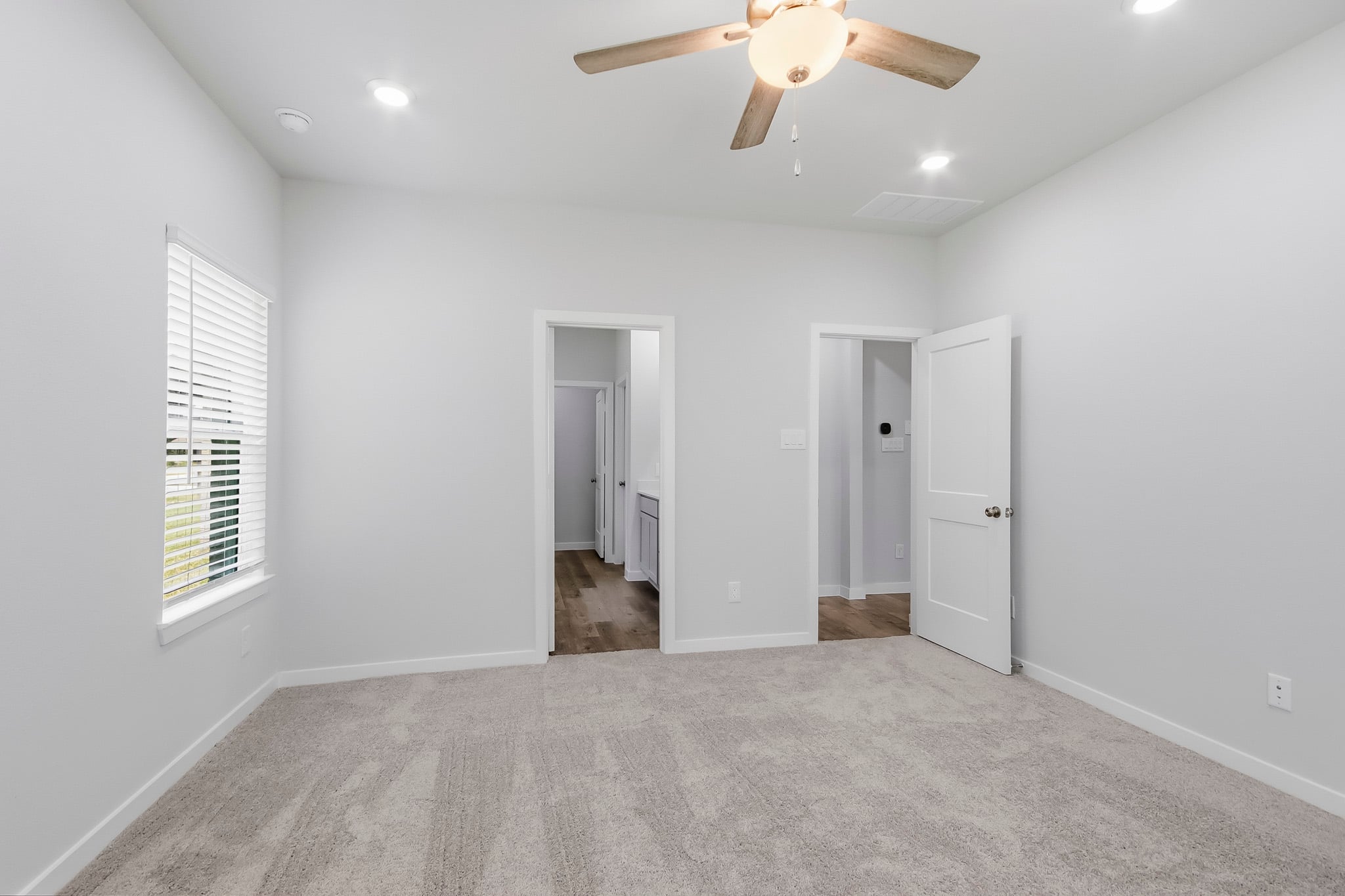 A room with a fan and a carpet.