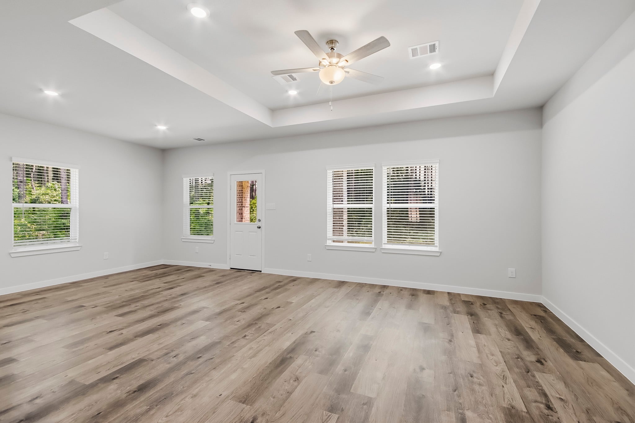 A room with a wood floor and a ceiling fan.