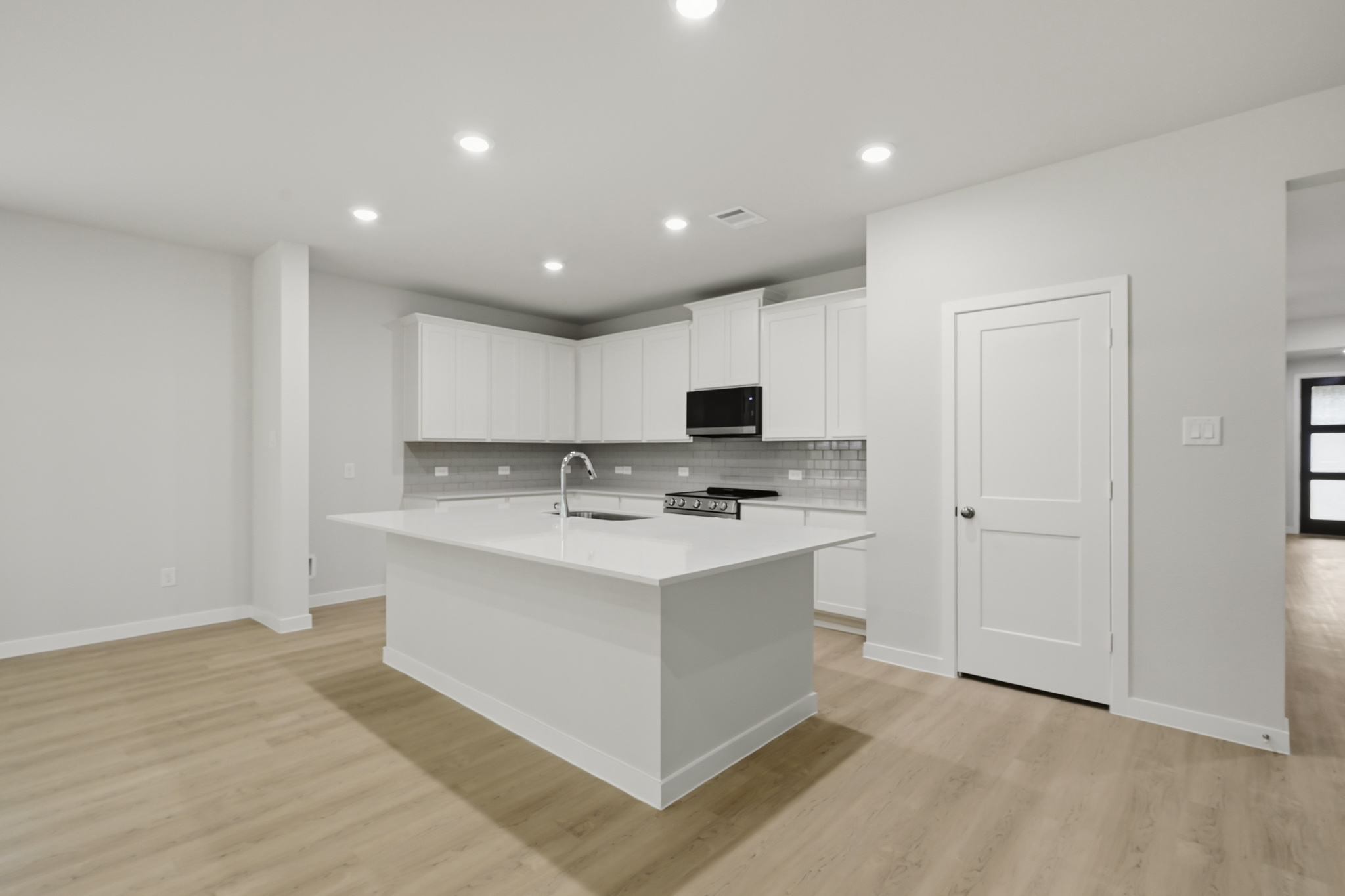 A kitchen with white cabinets.