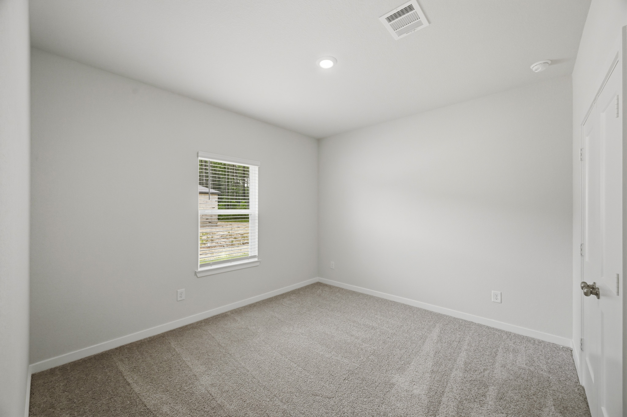 A room with a carpet and a window.