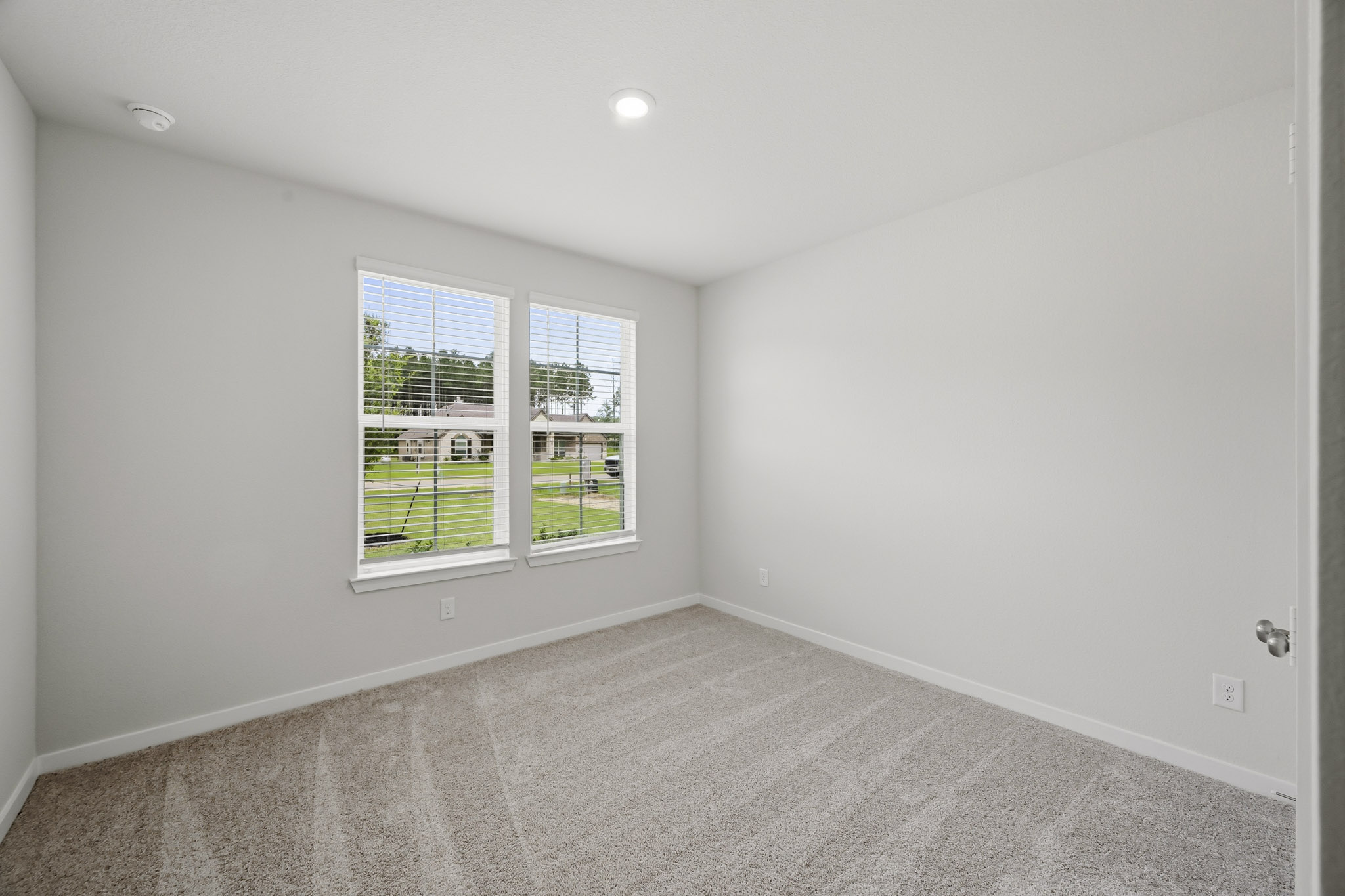 A room with a window and a carpet.