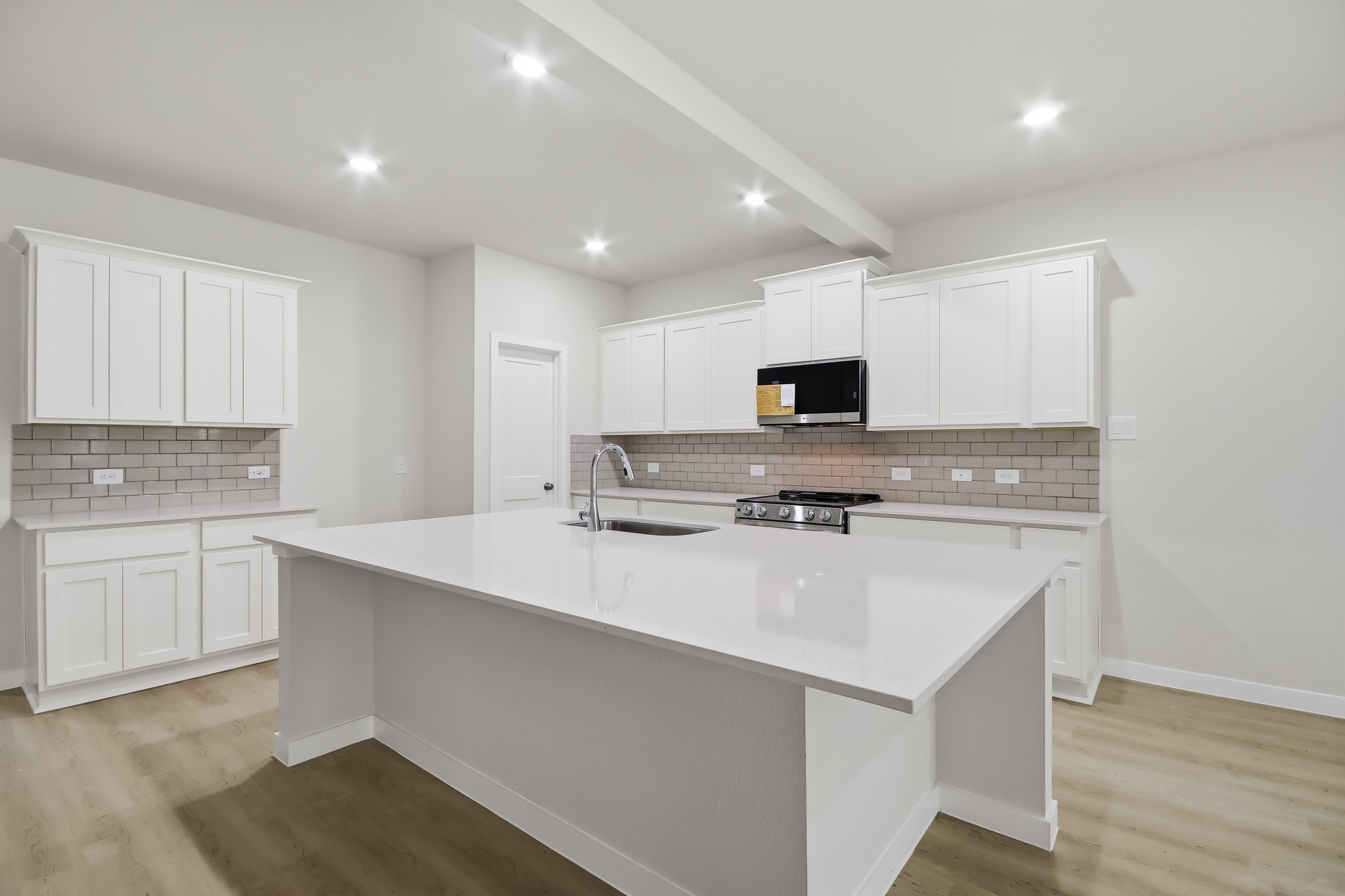 A kitchen with white cabinets.