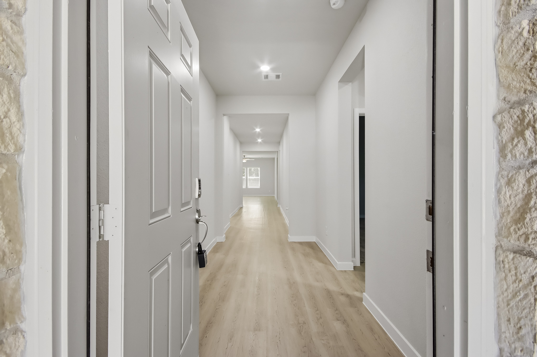 A long hallway with white doors.