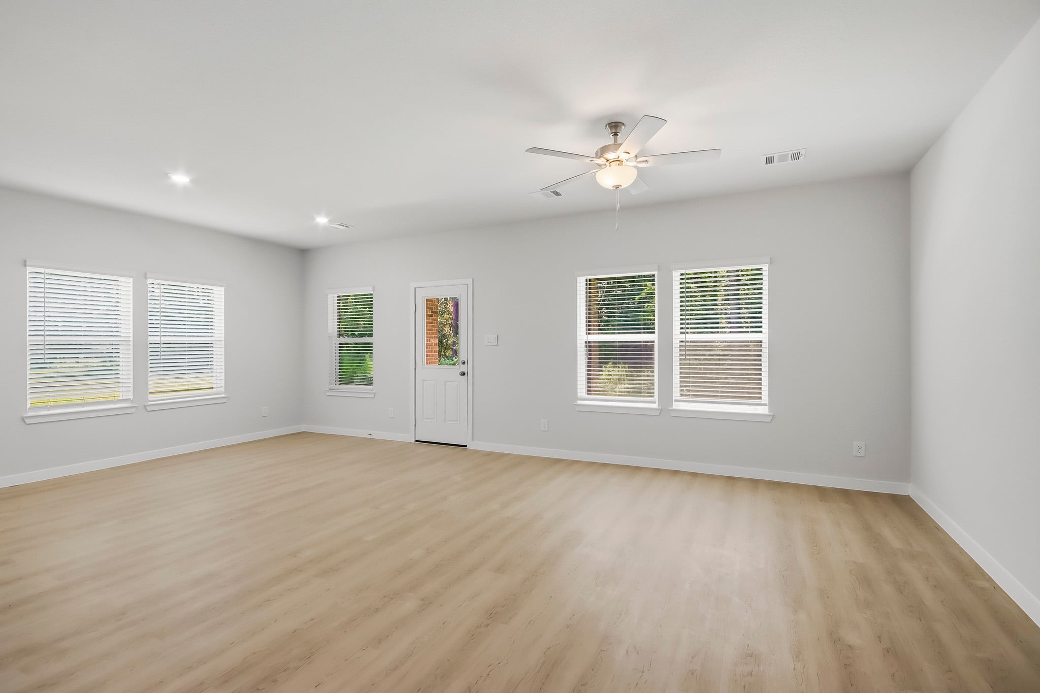 A room with a wood floor and a ceiling fan.