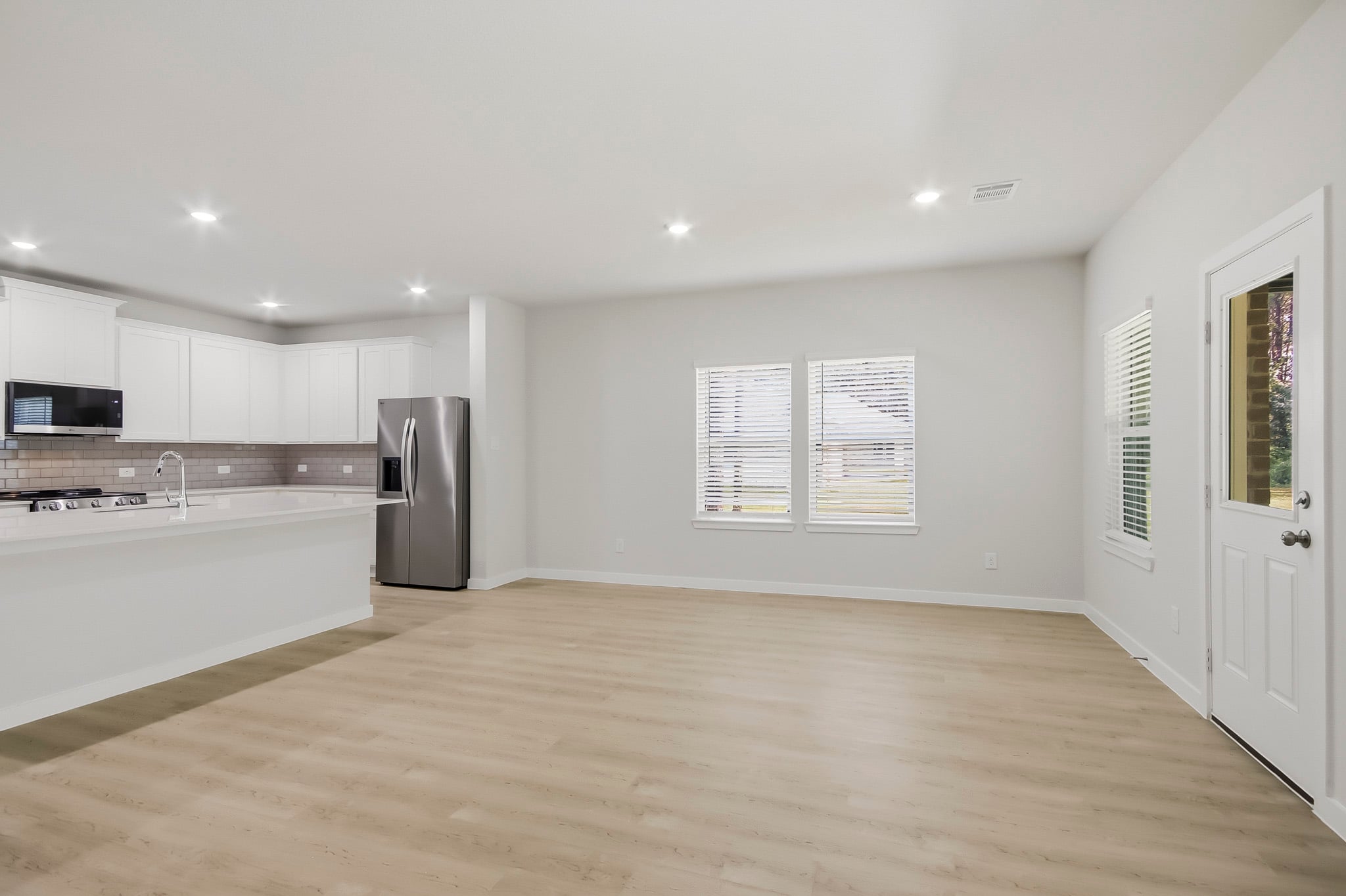 A large kitchen with a wood floor.