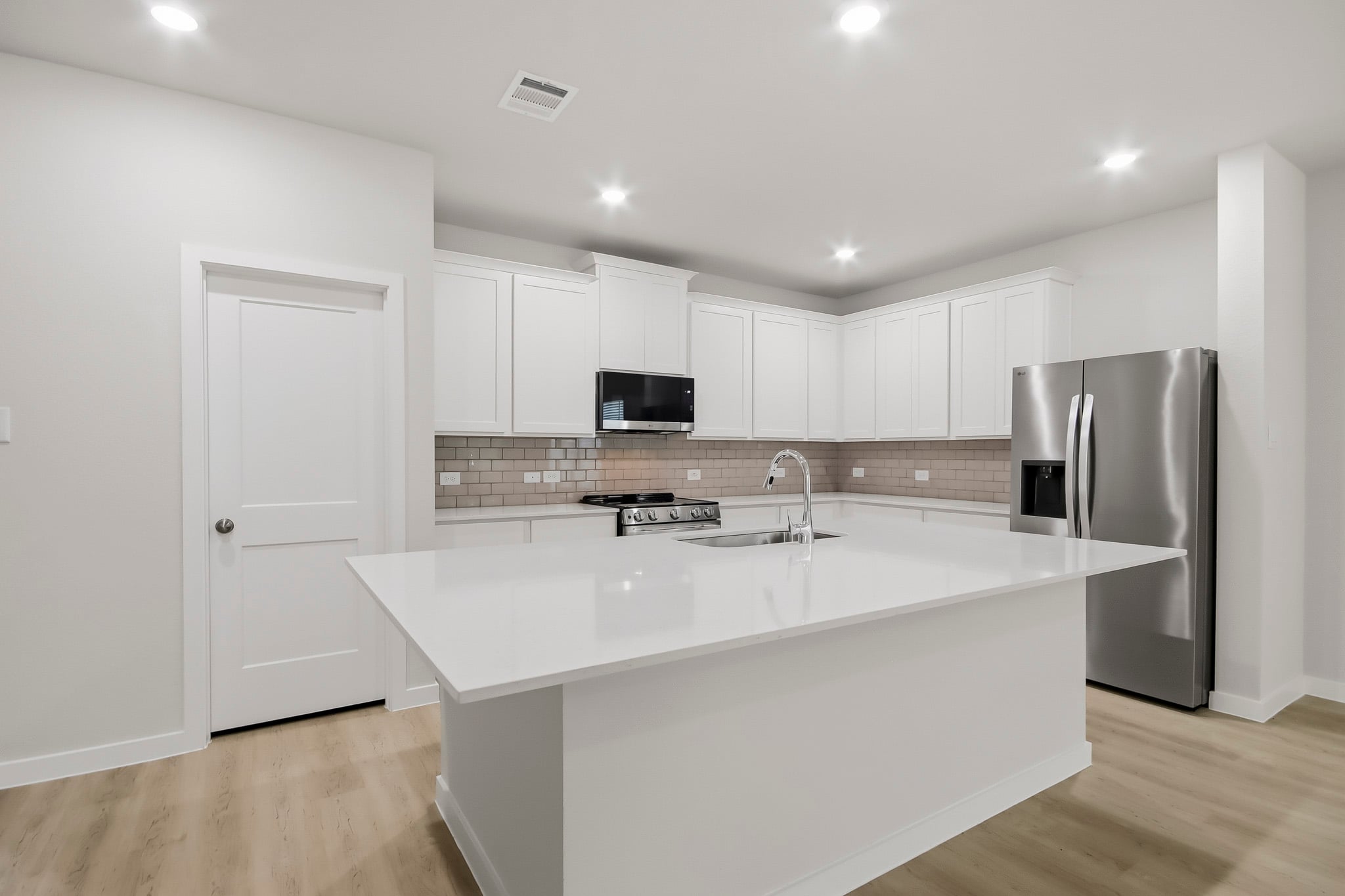 A kitchen with white cabinets.