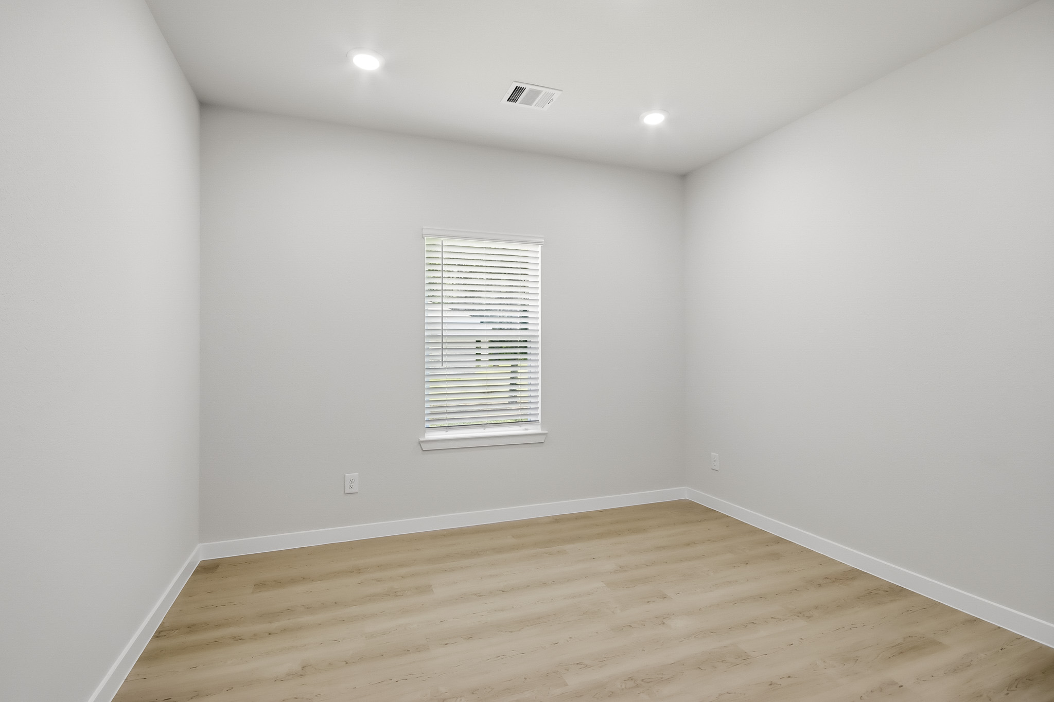 A room with a wood floor and a window.