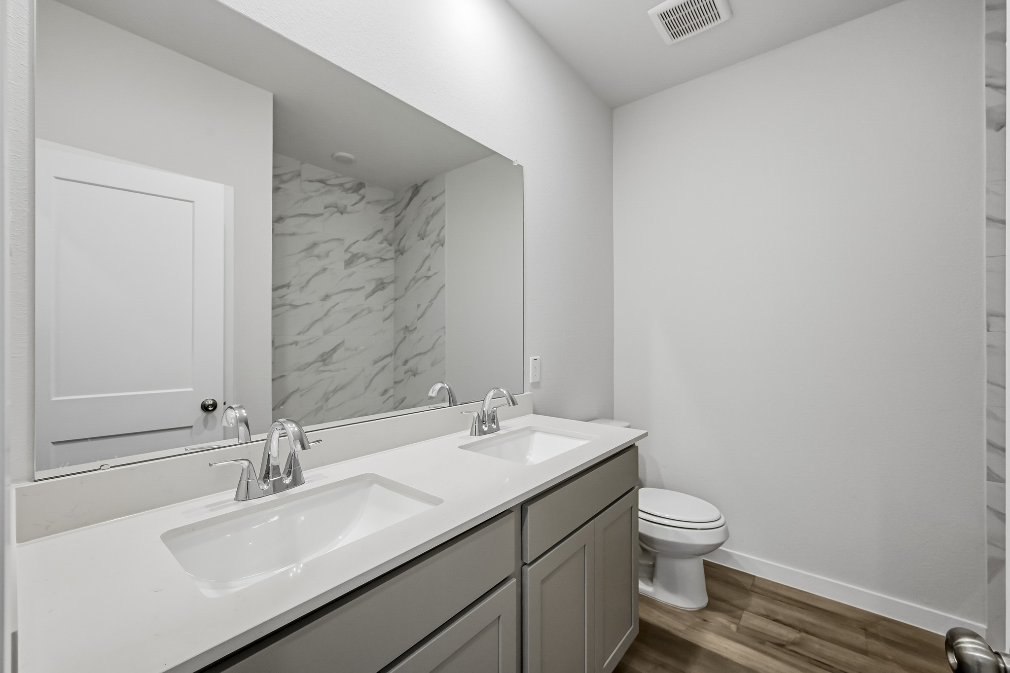 A bathroom with a large mirror.
