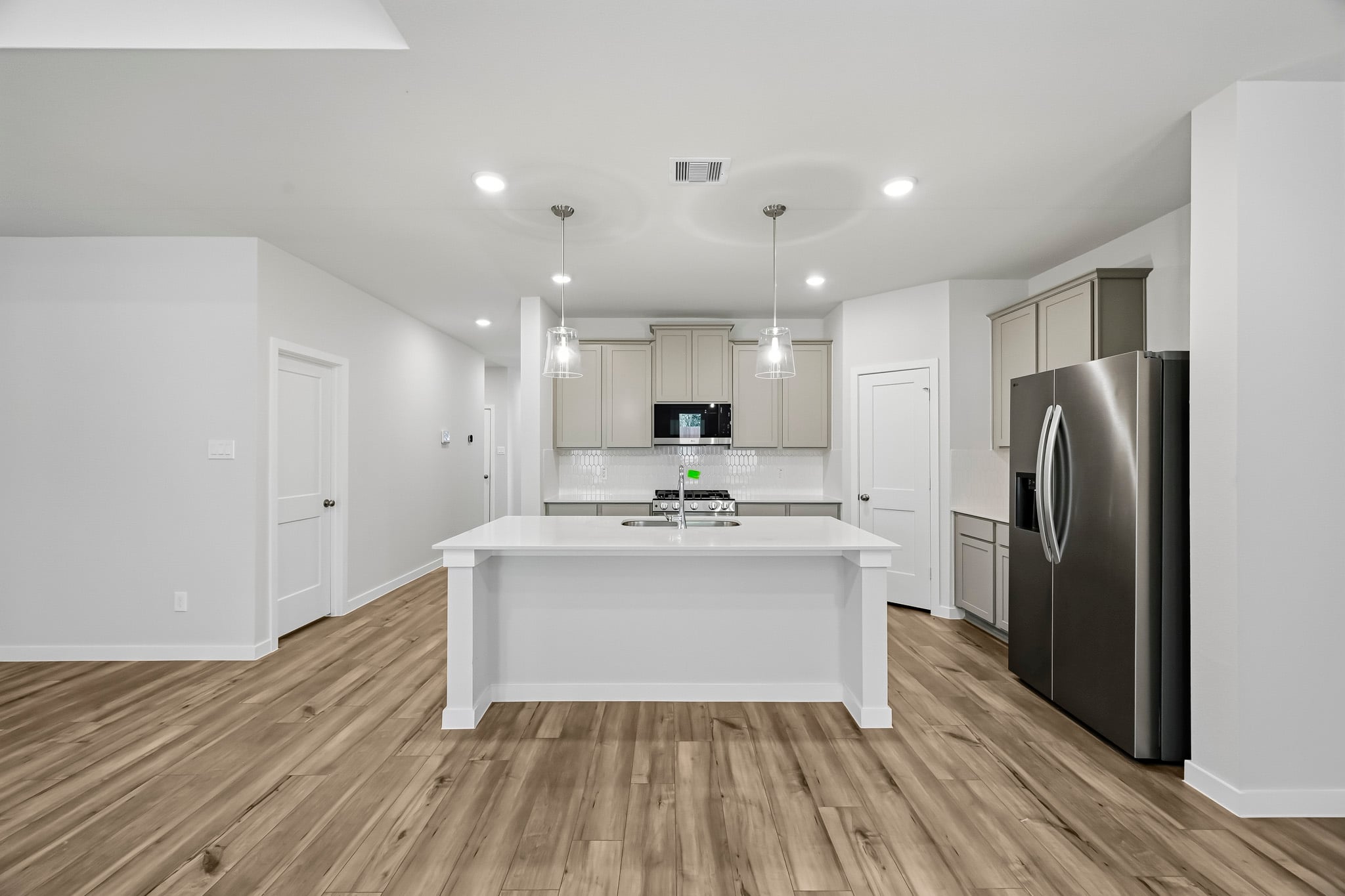 A kitchen with white cabinets.