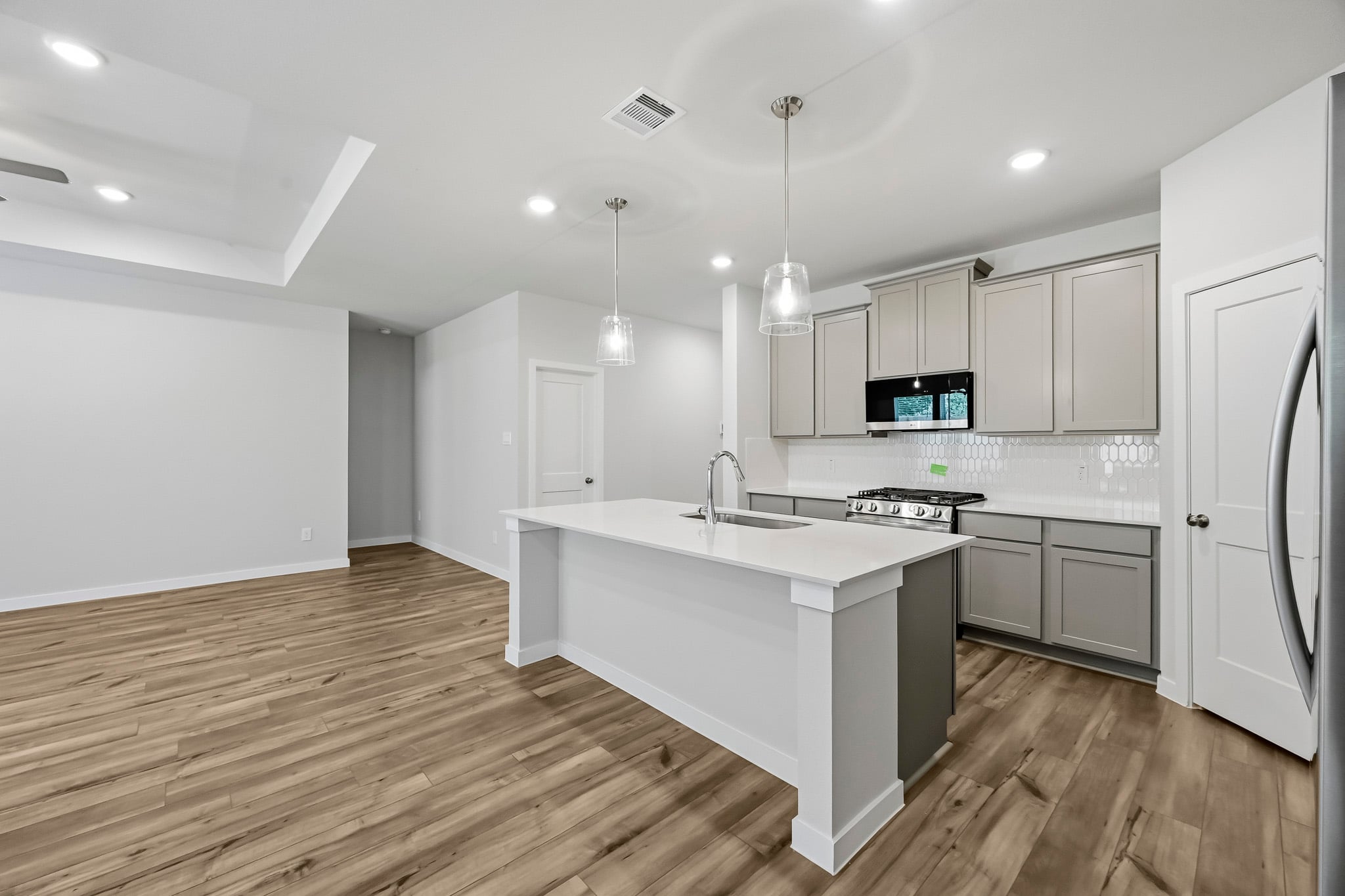 A kitchen with white cabinets.