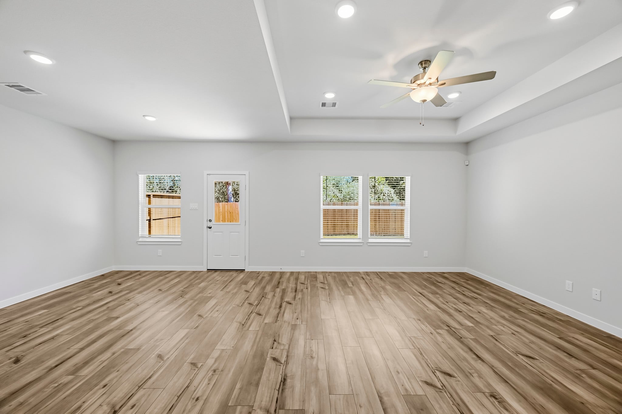A room with a wood floor and a ceiling fan.