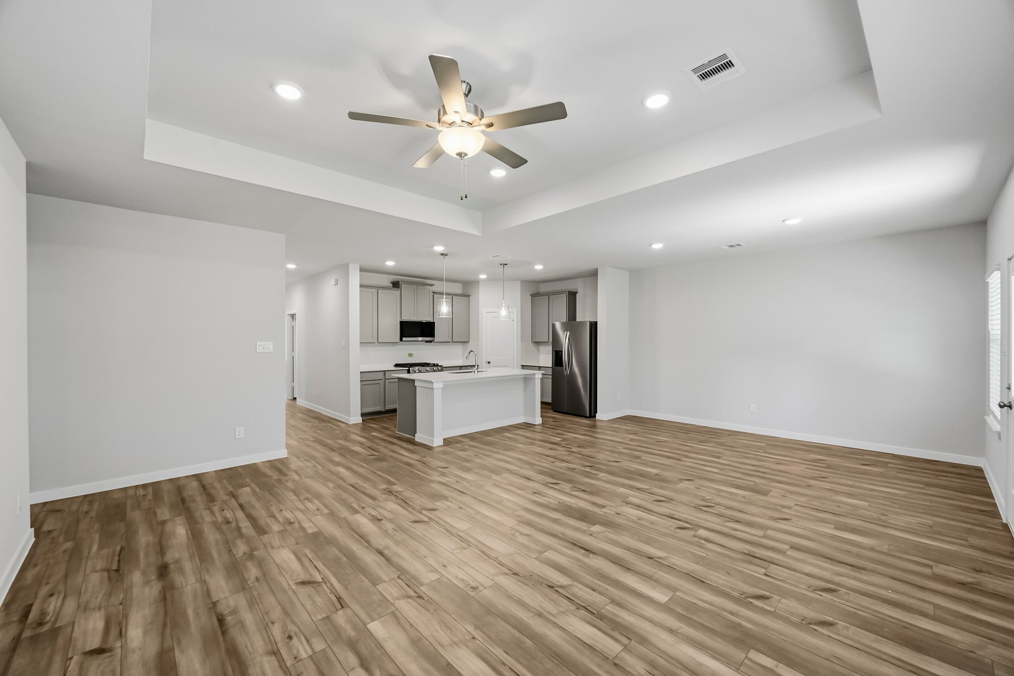 A large kitchen with a wood floor.