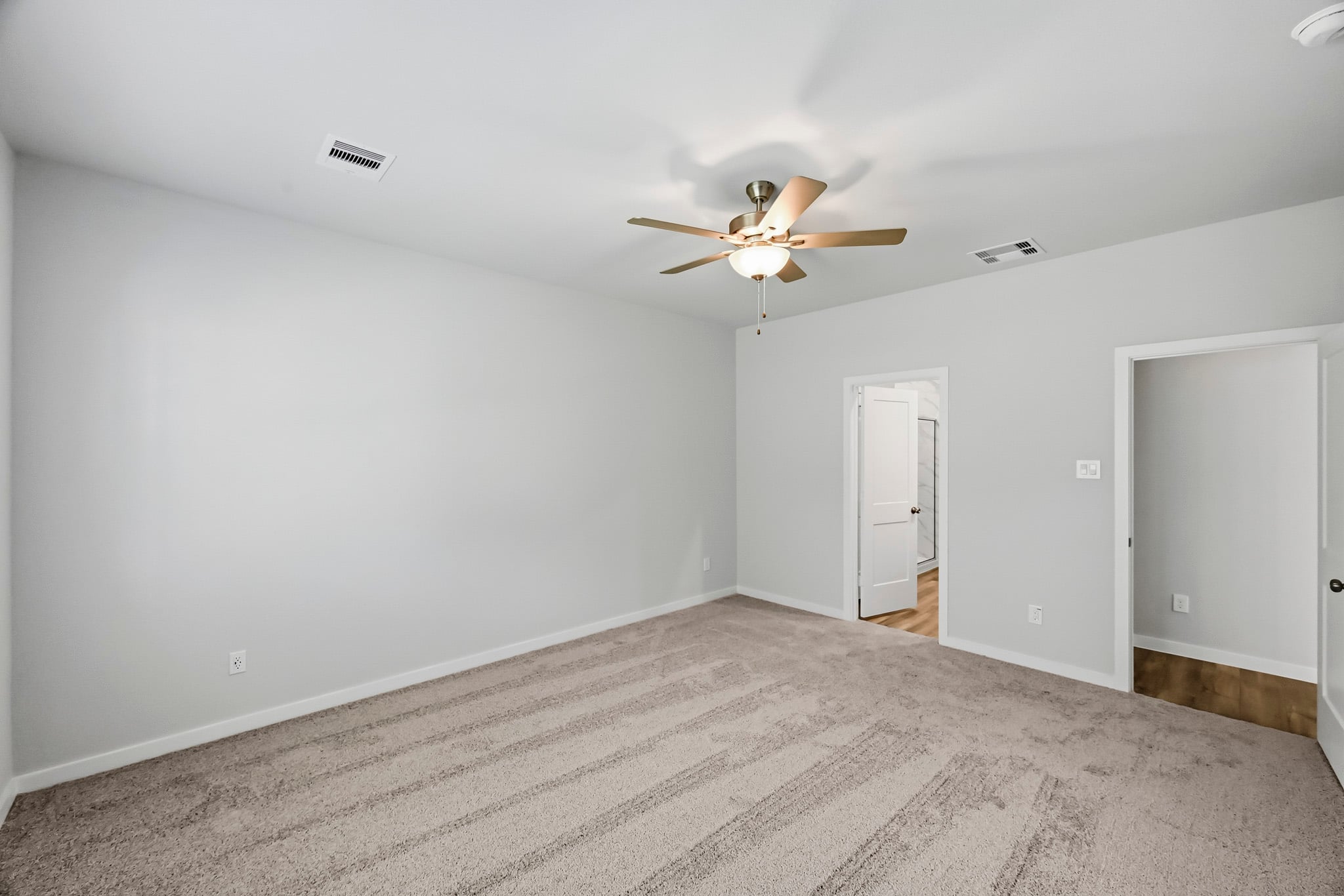 A room with a ceiling fan and a door.