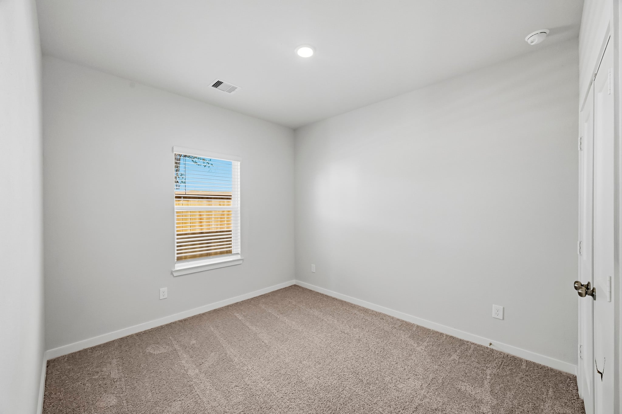 A room with a window and carpet.