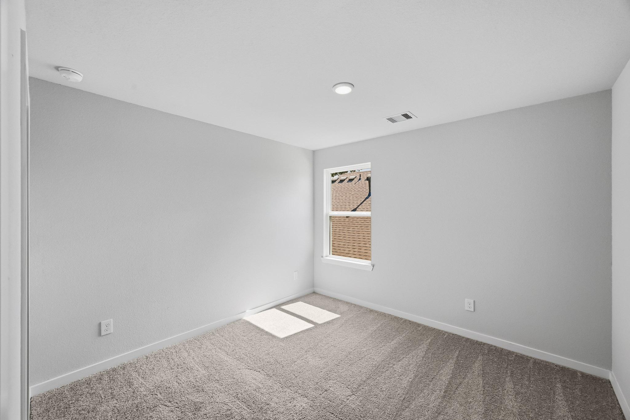 A room with a window and carpet.