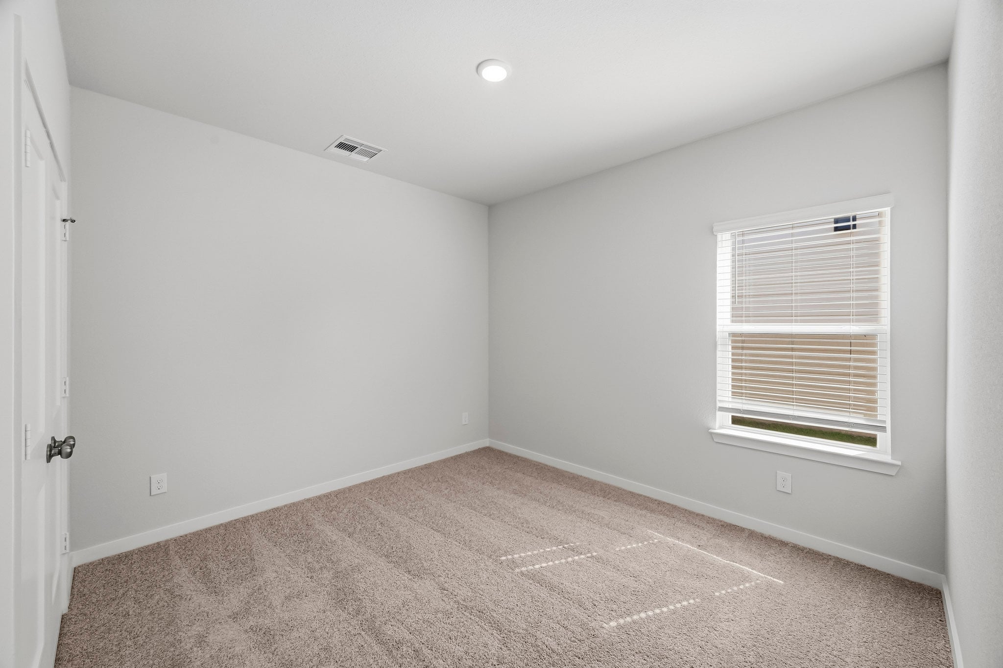 A room with a carpet and a window.