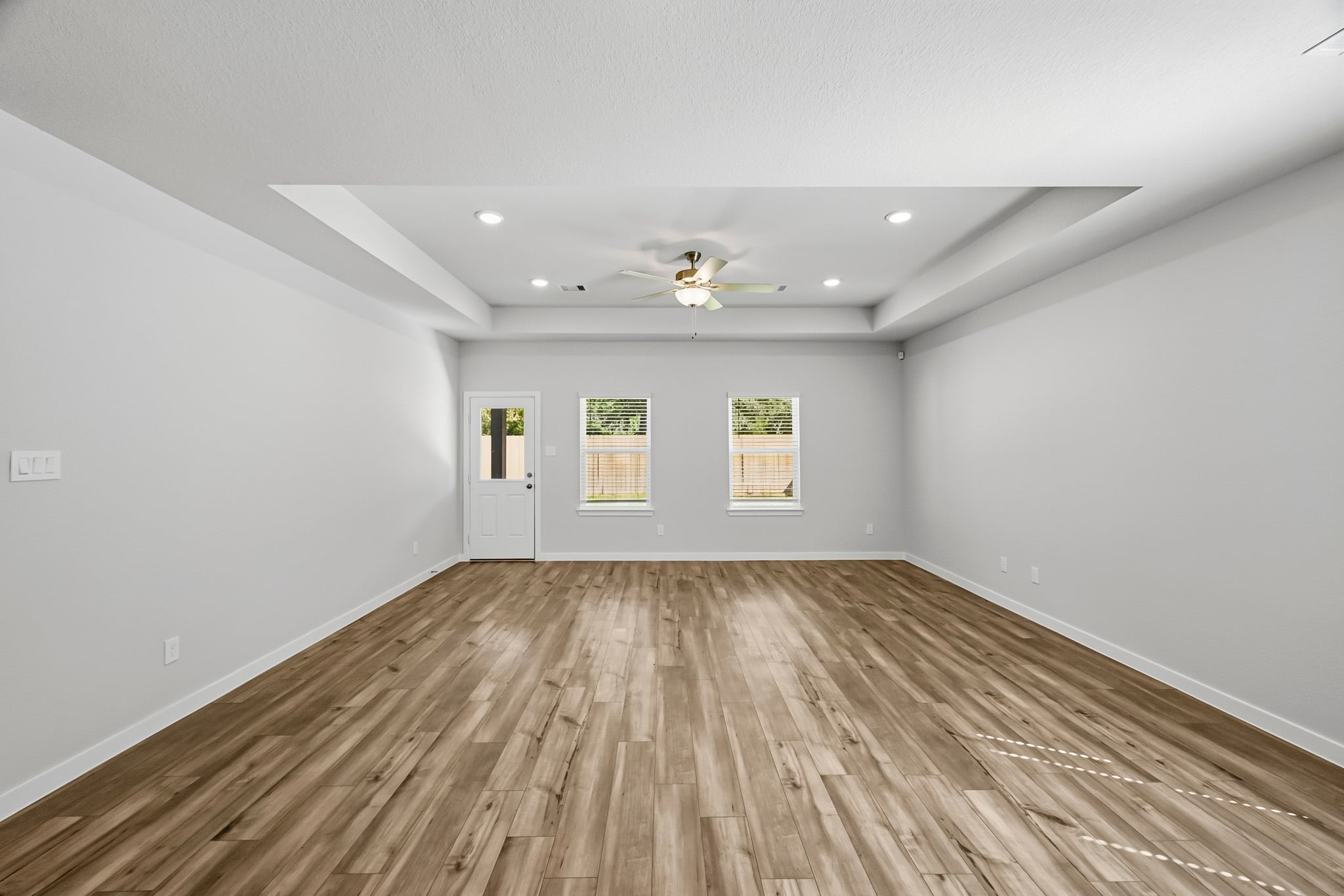 A room with a wood floor and a ceiling fan.