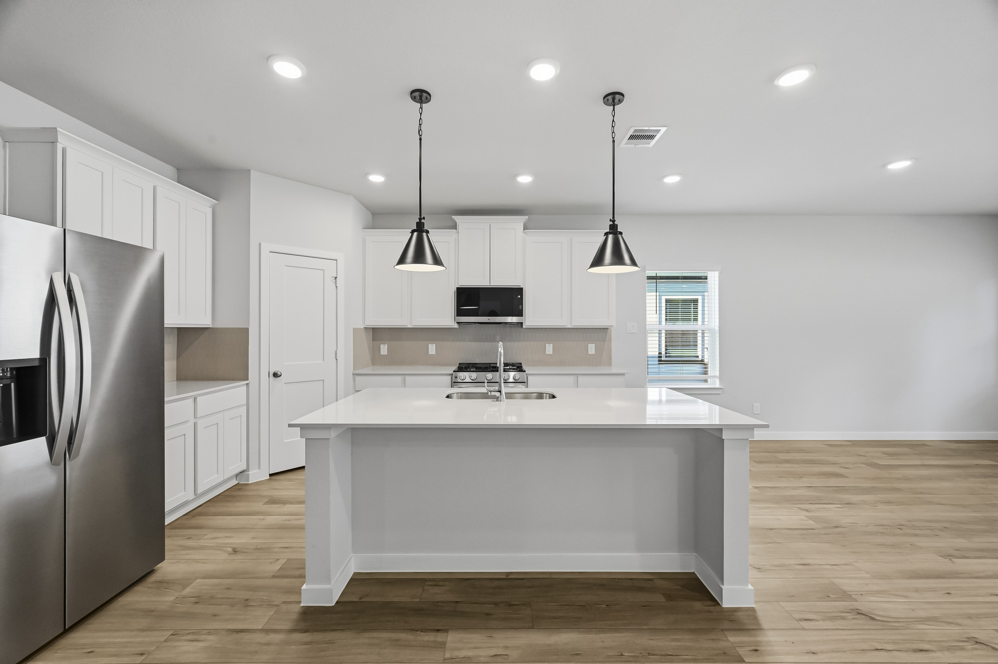 A kitchen with white cabinets.
