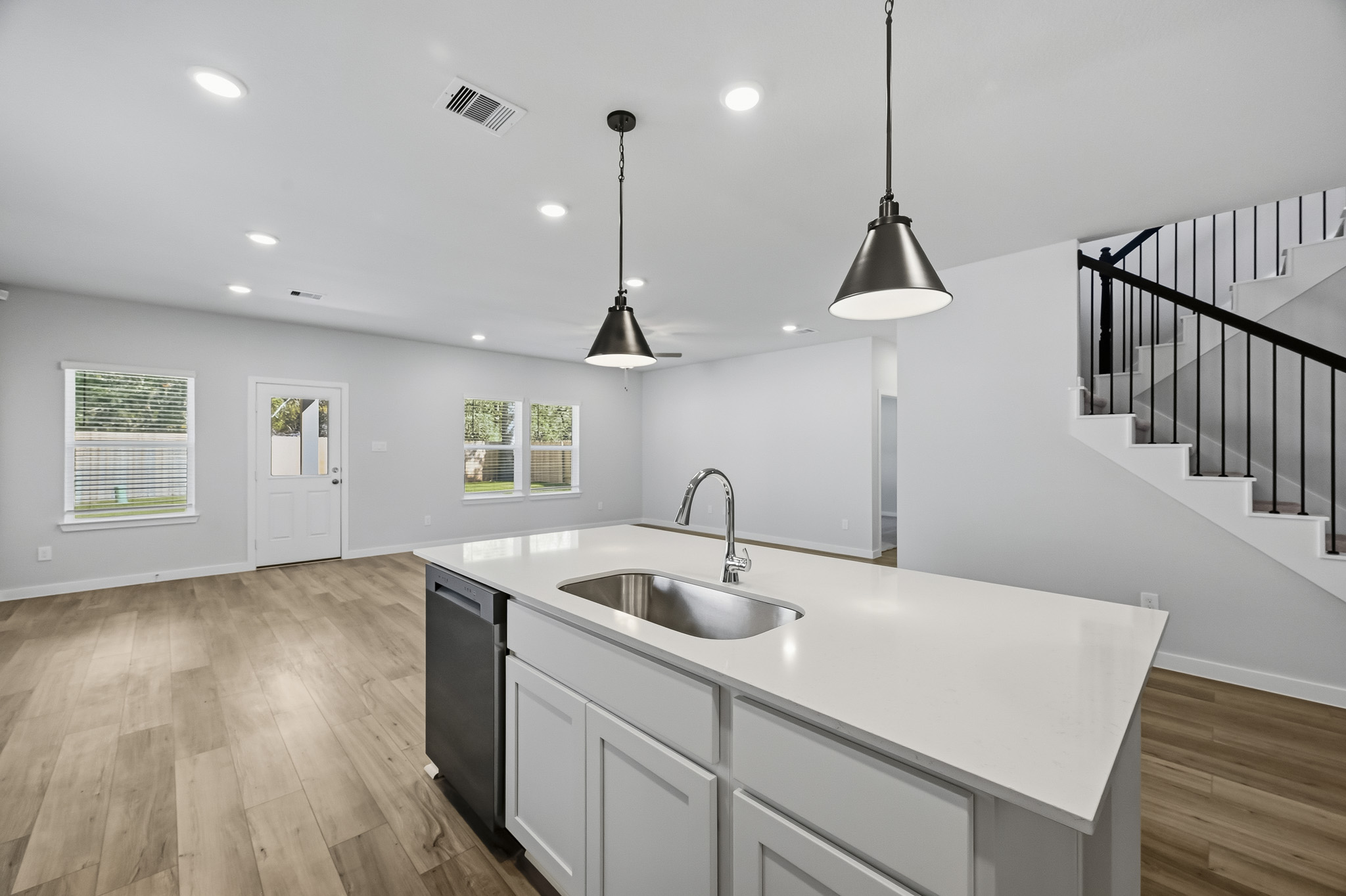 A kitchen with a sink and a bar stool.