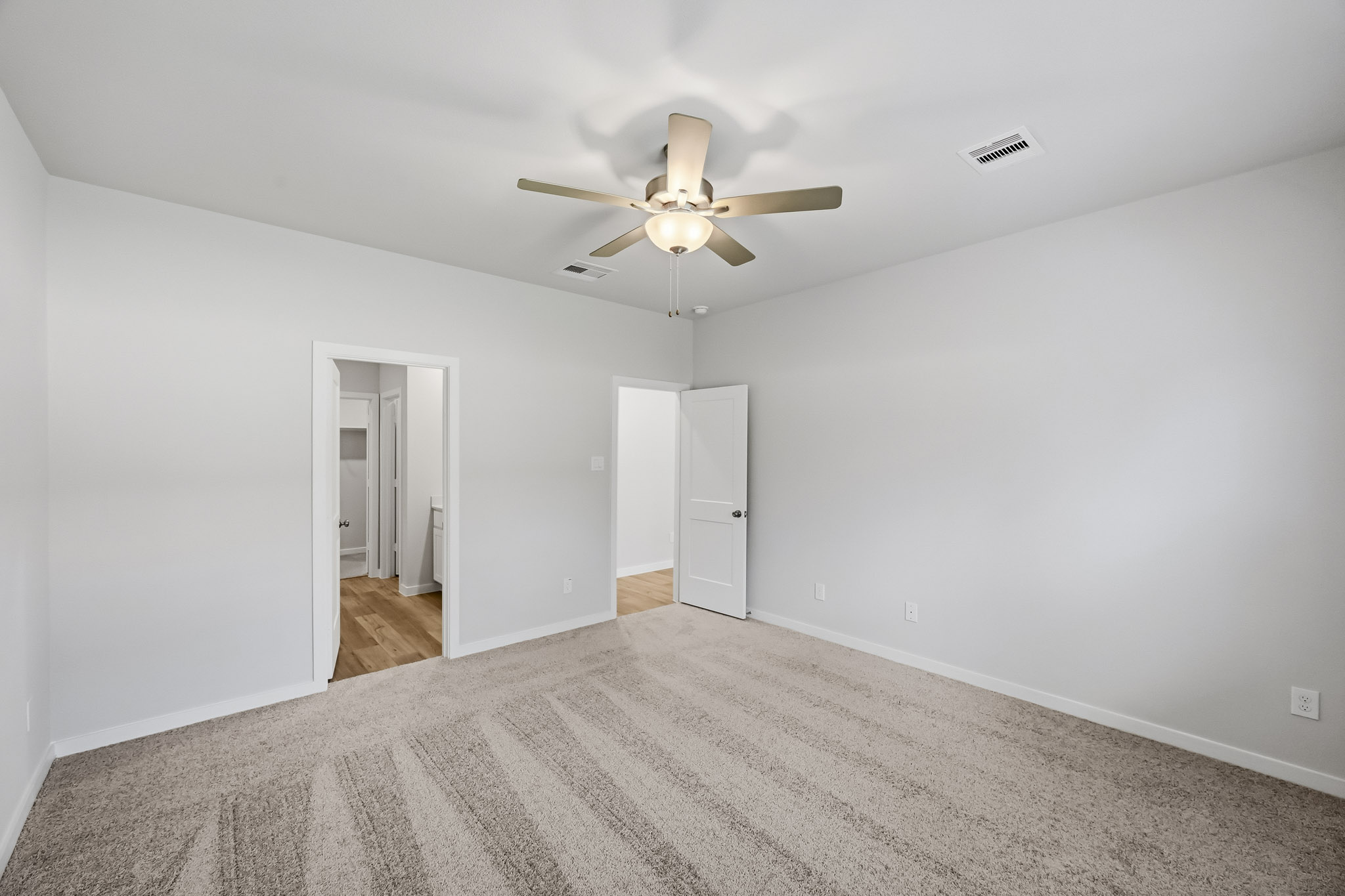 A room with a ceiling fan and a door.