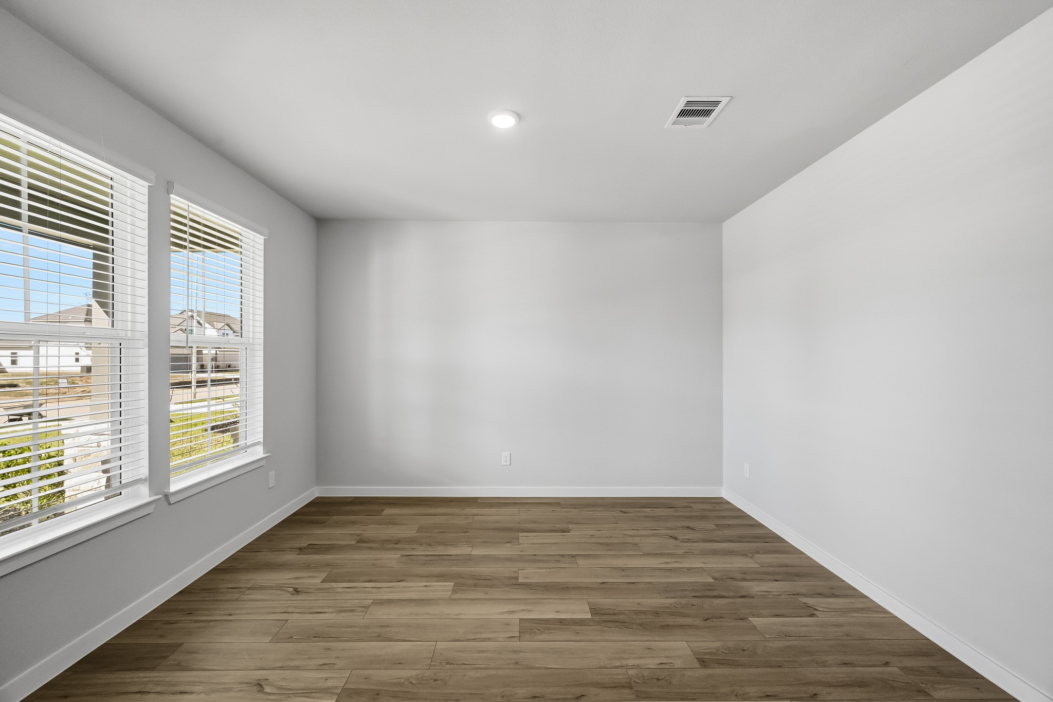 A room with windows and wood floor.