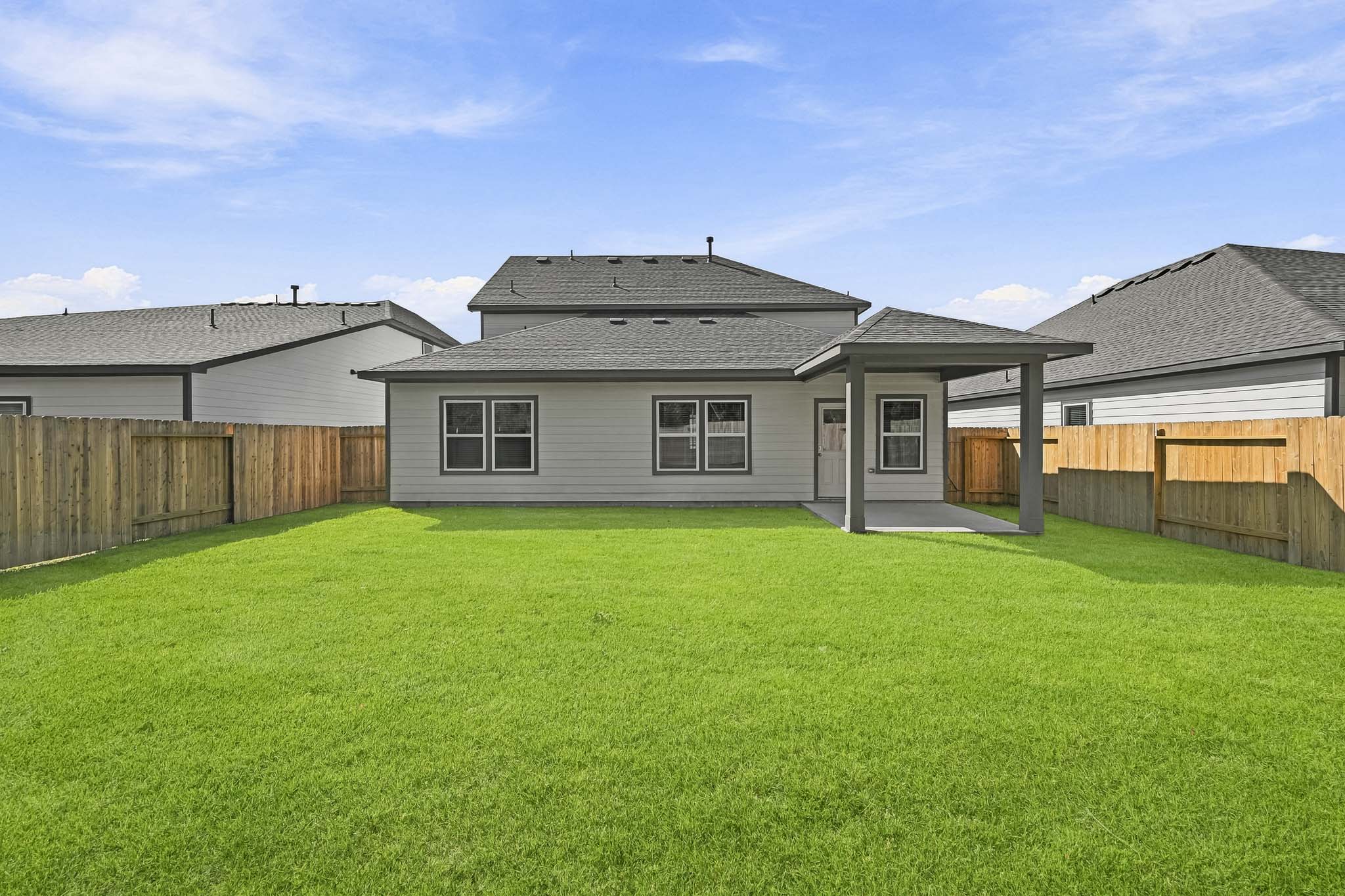 A house with a fence and grass.