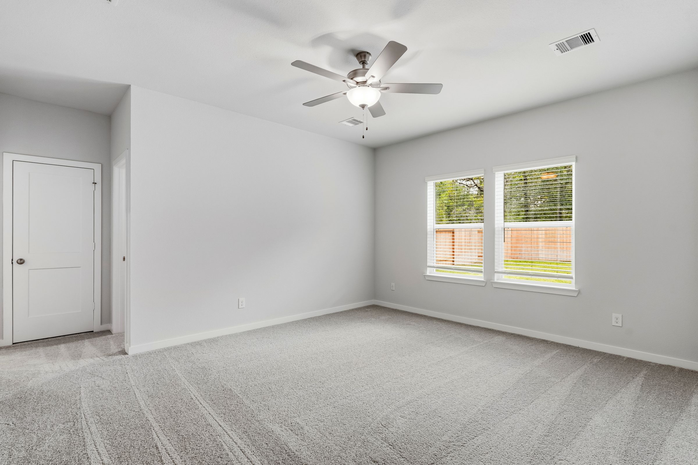 A room with a ceiling fan and a window.
