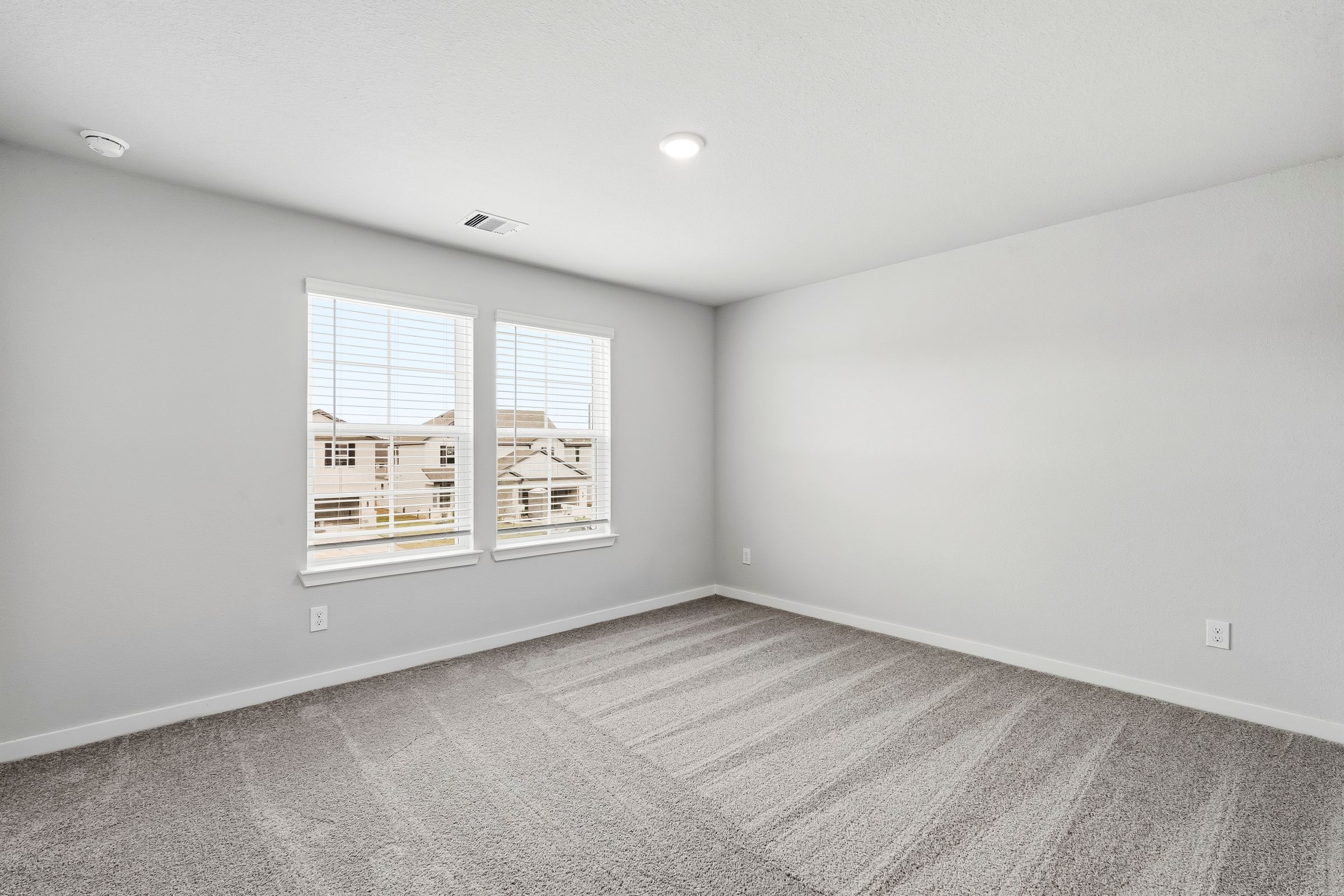 A room with a window and a carpet.