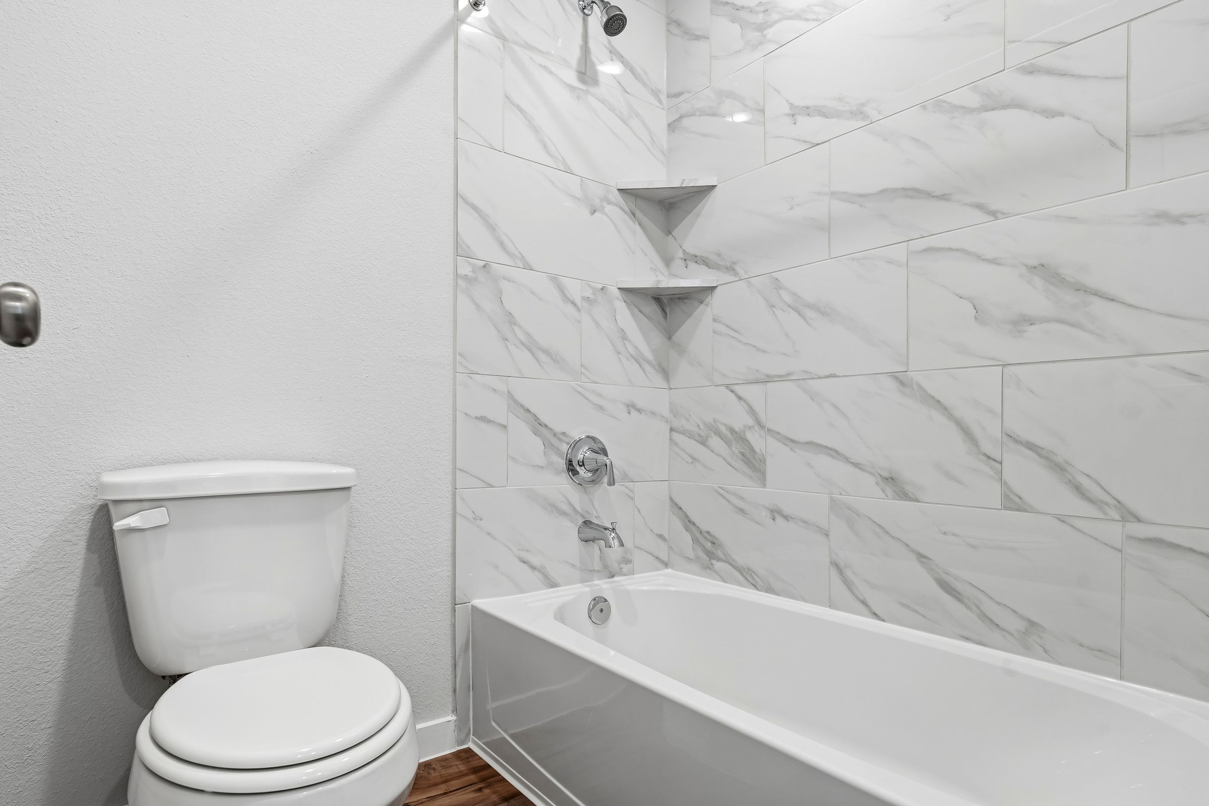 A bathroom with a toilet and bathtub.