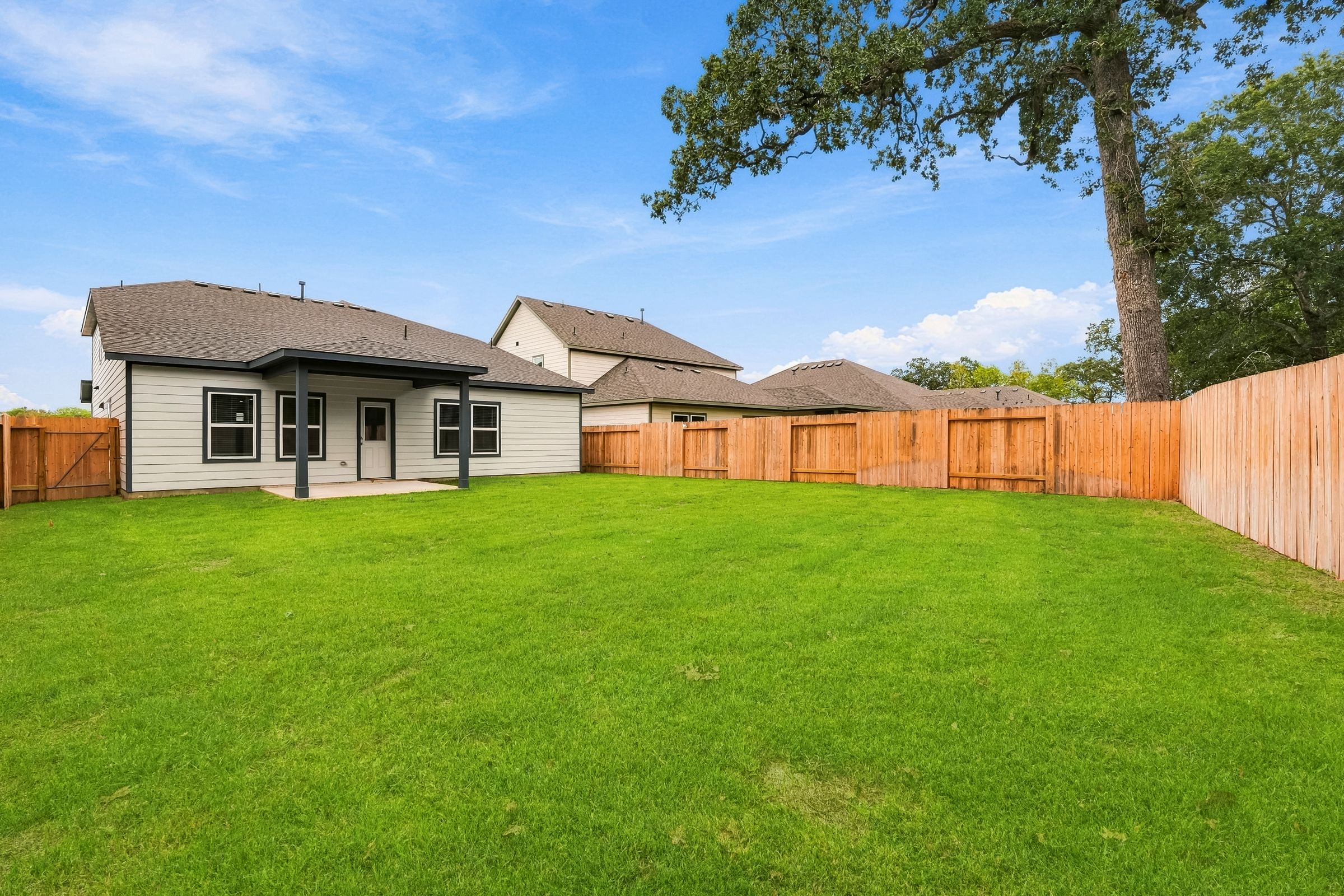 A fenced in yard with a house in the background.