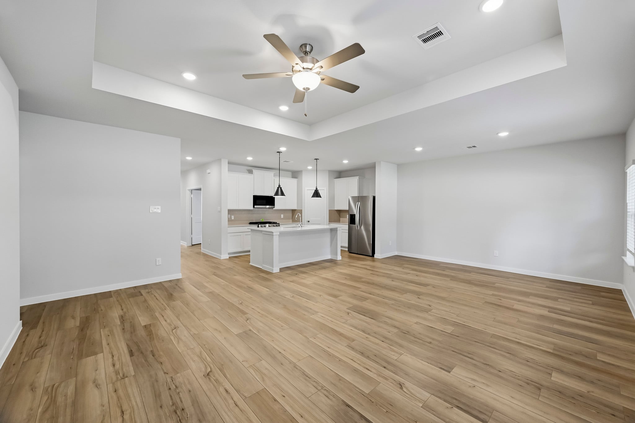 A large kitchen with a wood floor.