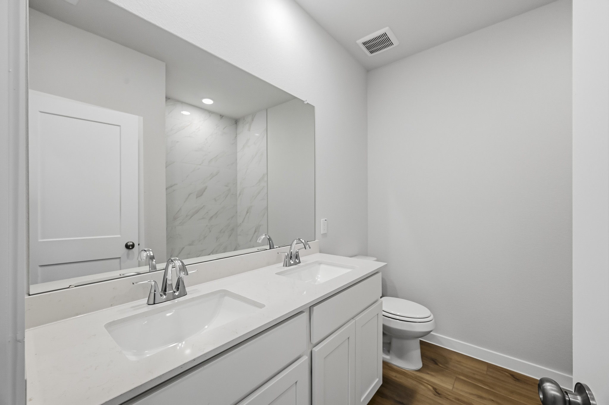 A bathroom with a large mirror.
